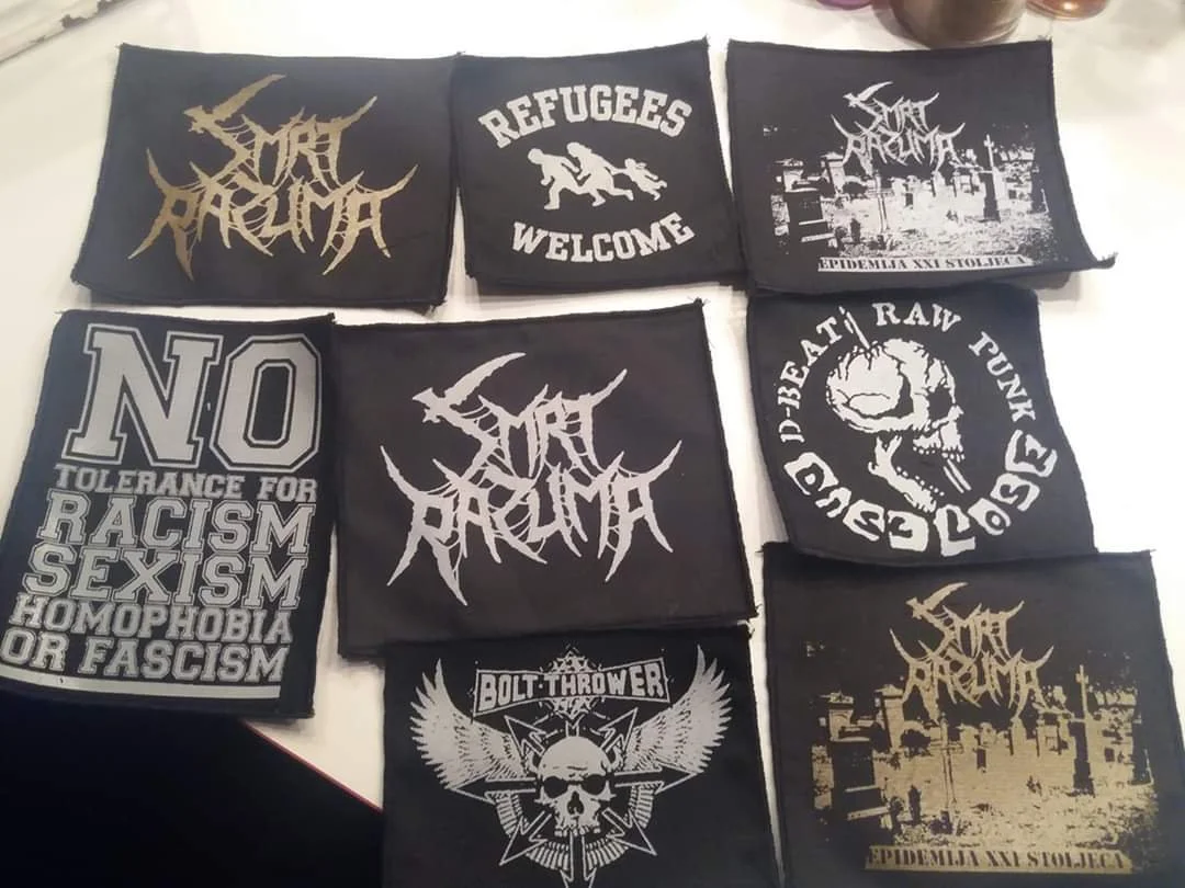 Collection of black cloth patches with white and gold graphics and text, featuring bands and slogans related to punk and hardcore music scenes.