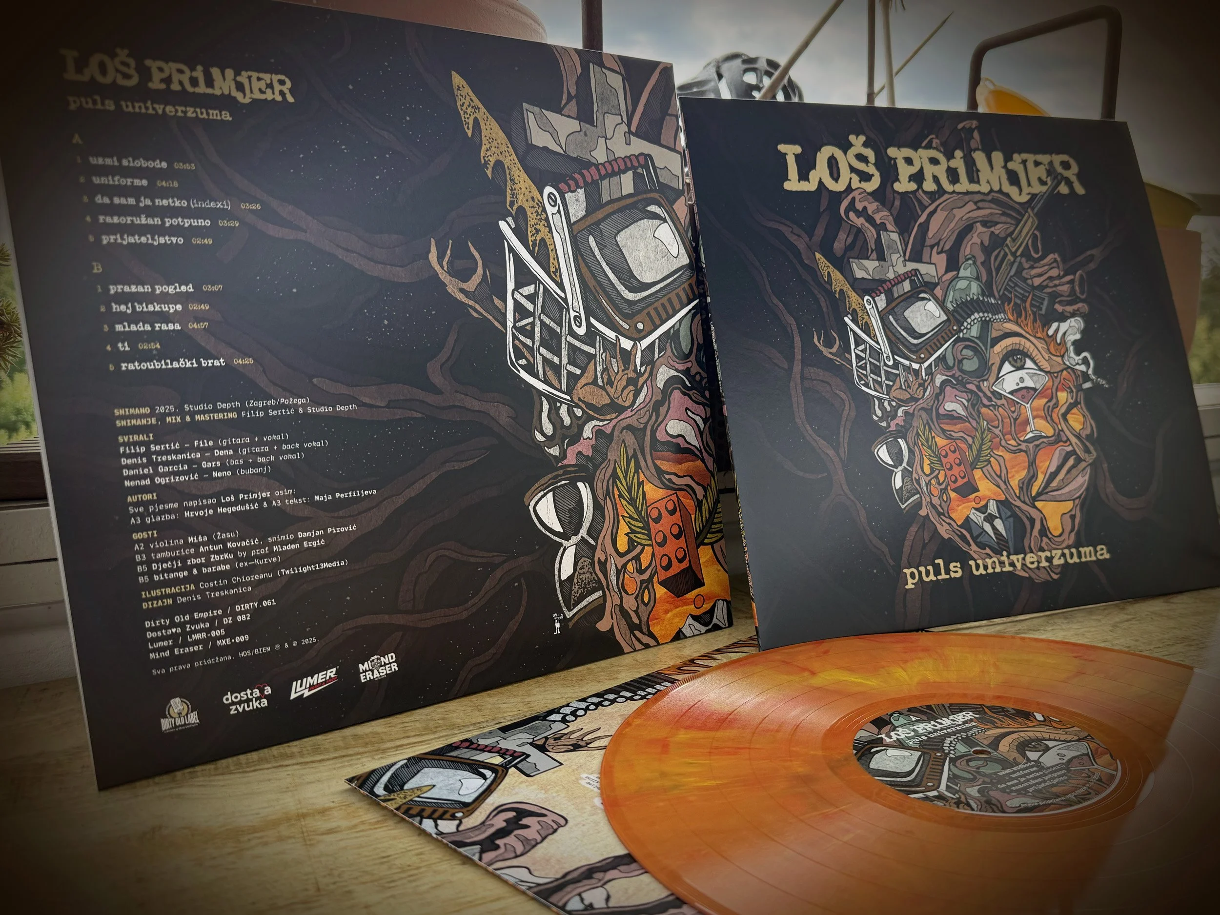 Two records from Los Primjer pull universal music label, one with a colorful eye-catching illustration of a tree and electronic equipment, and the other with a tracklist and credits. The records have a marbled orange and pink color.