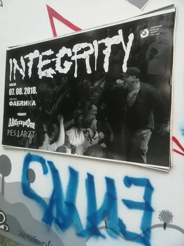 Black and white poster with the word 'INTEGRITY' in large, stylized font, advertising an event on 07.08.2018 at a student cultural center in Novi Sad, supported by All Creep, Peliarzt, and others, with a crowd of people in the background.