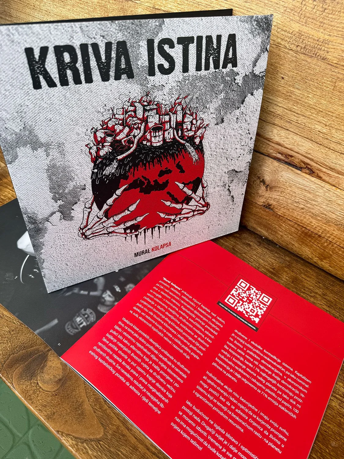Book cover titled 'Kritva Istina' with an illustration of a human head with a cityscape on top, featuring pipes and wires, and a skeletal hand gripping the head. The background is textured gray.