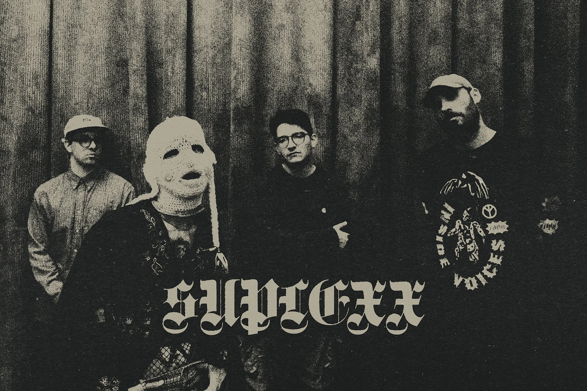 Black and white group photo of four SUPLEXX band members standing in front of a curtain.