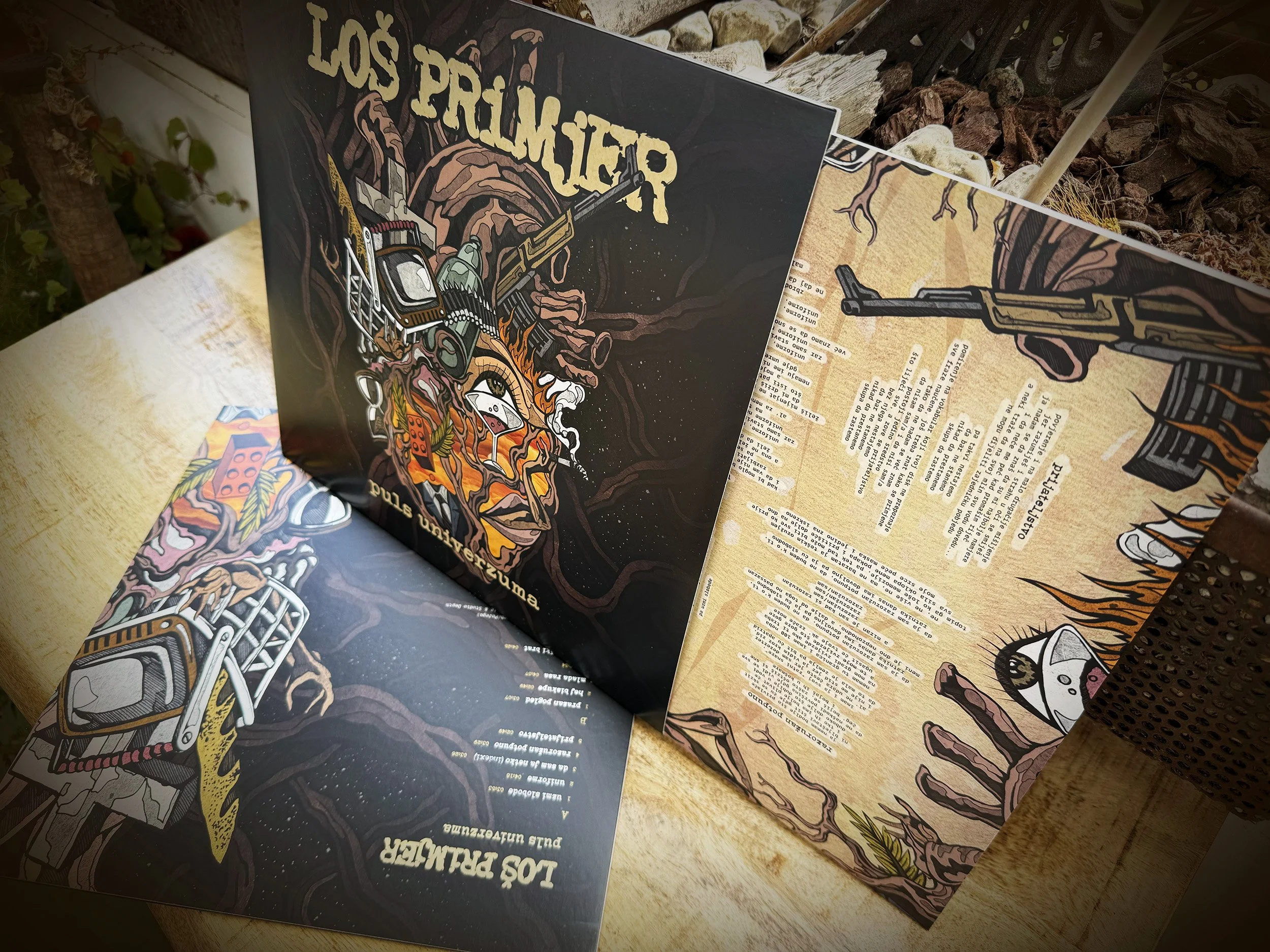 Close-up of a booklet cover with a dark, illustrative design featuring a torch and a face, with the title 'Los Primjer' and additional text in Spanish.