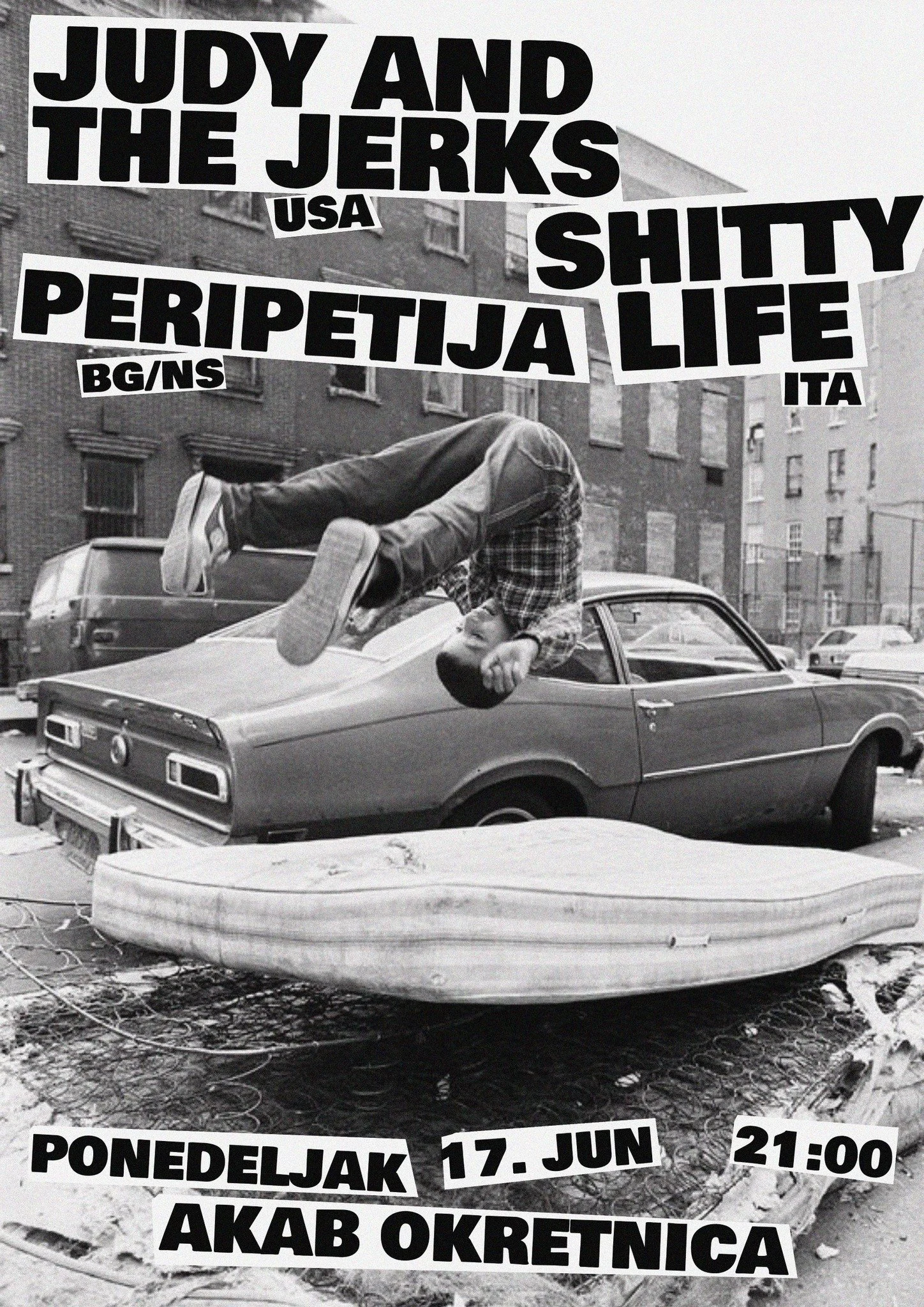A black and white photo of a person doing a headstand on the hood of a car on an urban street, with large, bold text overlaid advertising an event in Slovenian.