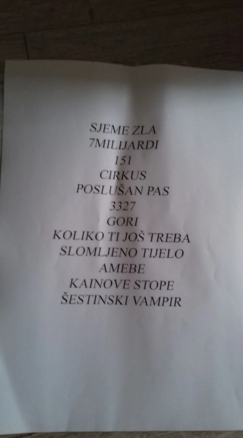 Set list or song lyrics in croatian language printed on a white sheet of paper with some creases.
