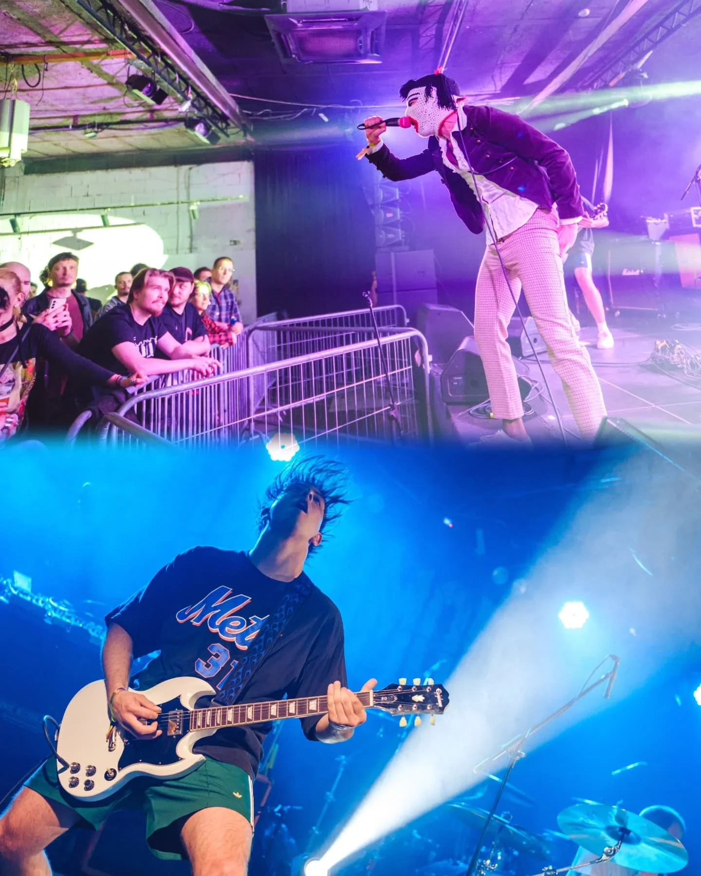 A live music performance featuring a singer wearing a mask, a blazer, and checkered pants, singing into a microphone. A guitarist wearing shorts and a band T-shirt is playing on stage. Audience members watch from behind a barrier, some taking photos.