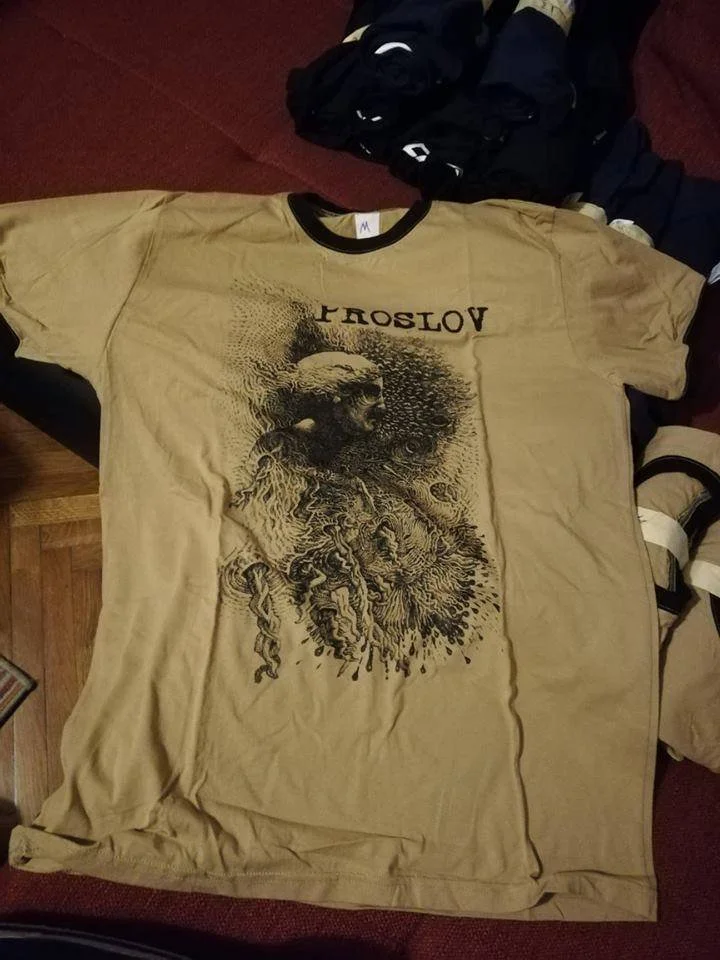 A beige T-shirt with a graphic design featuring a skull and abstract patterns, and the text 'PROSLOV' upside down.