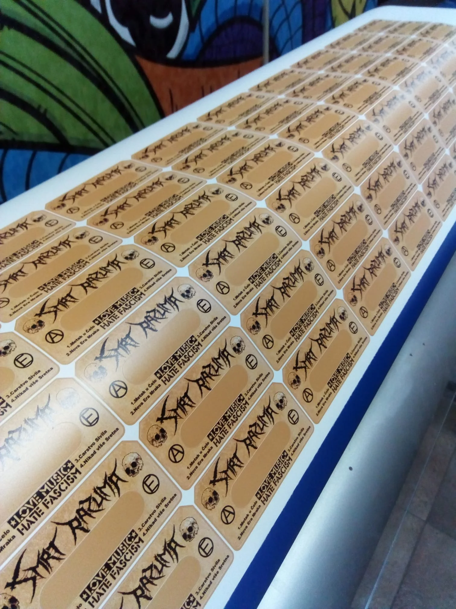 Multiple stacks of stickers with a yellow background, black text, skull illustrations, and symbols related to anti-fascist messaging.