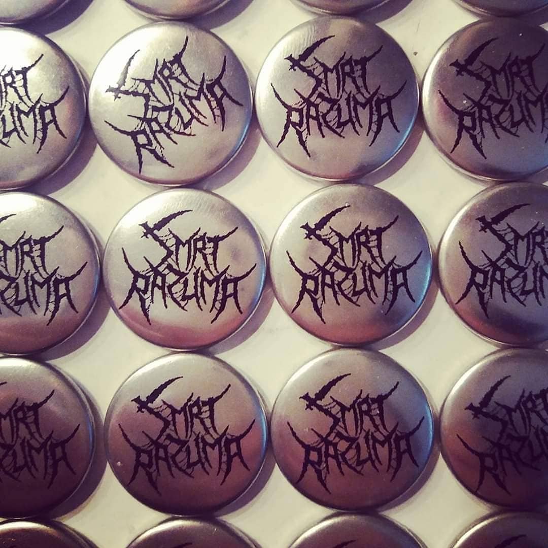 Multiple metallic buttons with the words 'Smrt Razuma' written in black gothic-style font, arranged in rows.