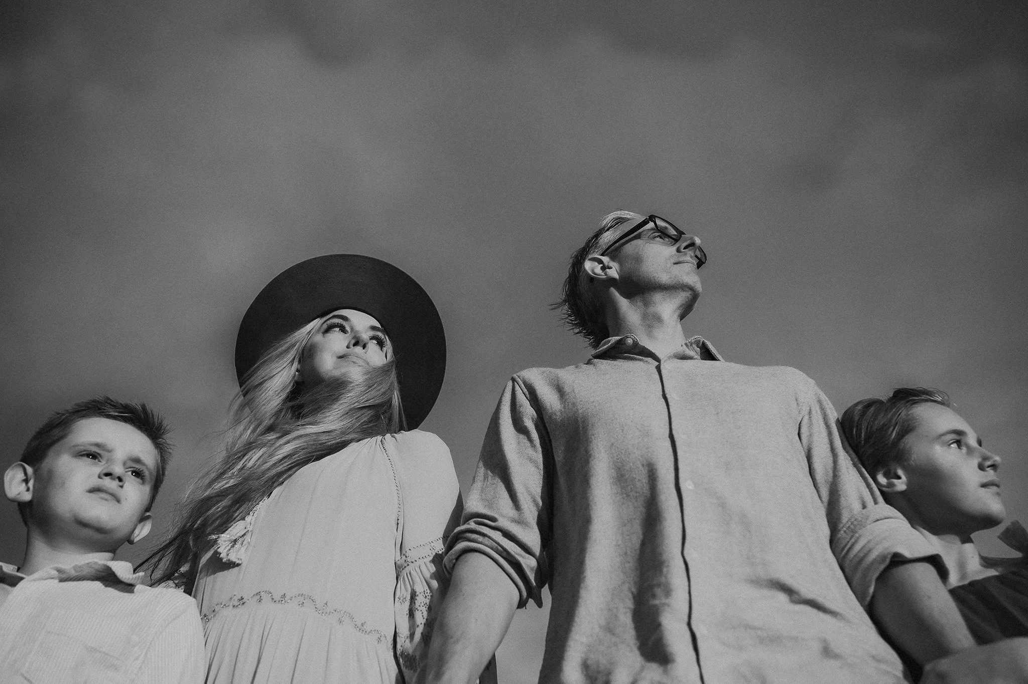 Black and white photo of family looking into the distance. 