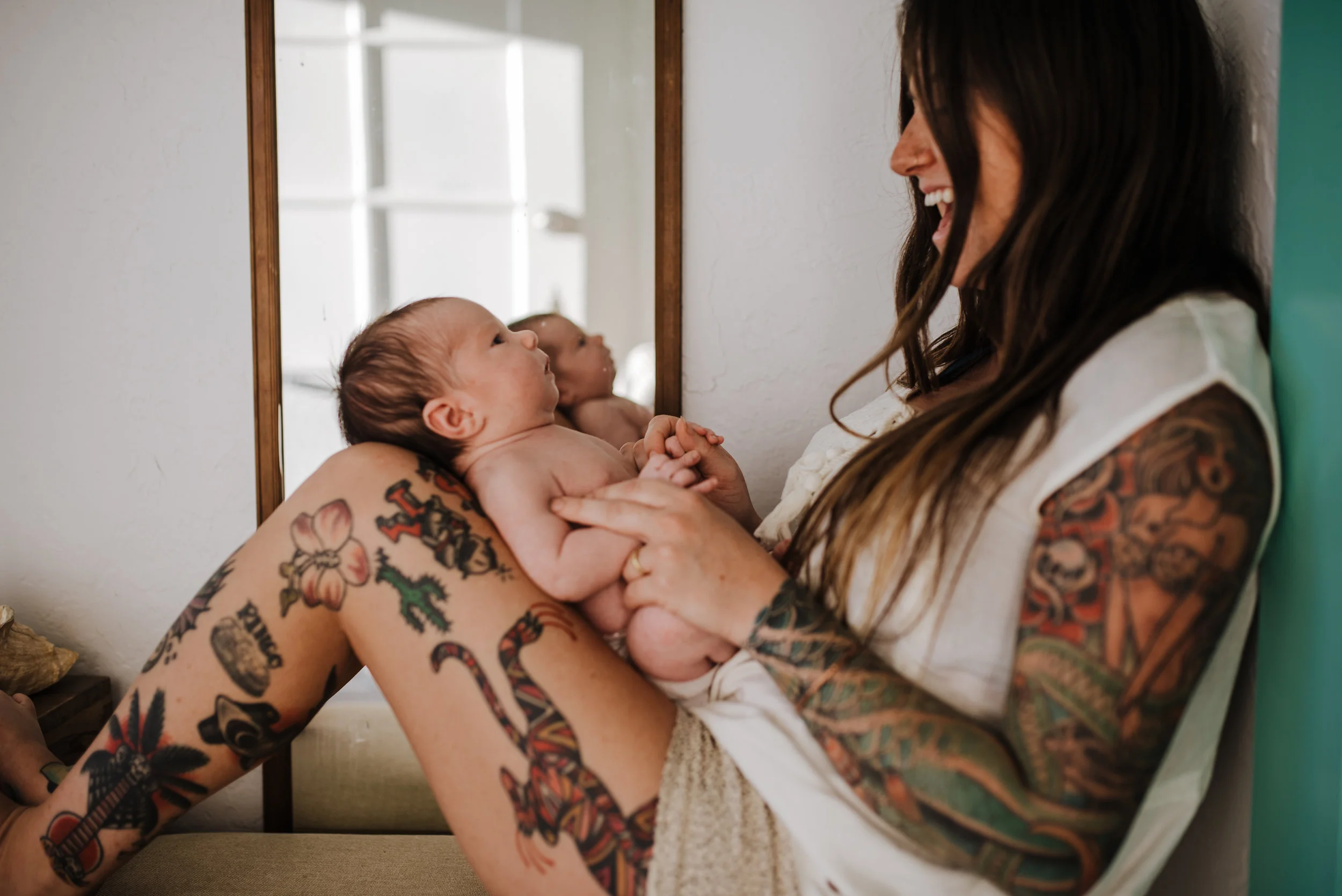Tattooed mother and baby at home. 