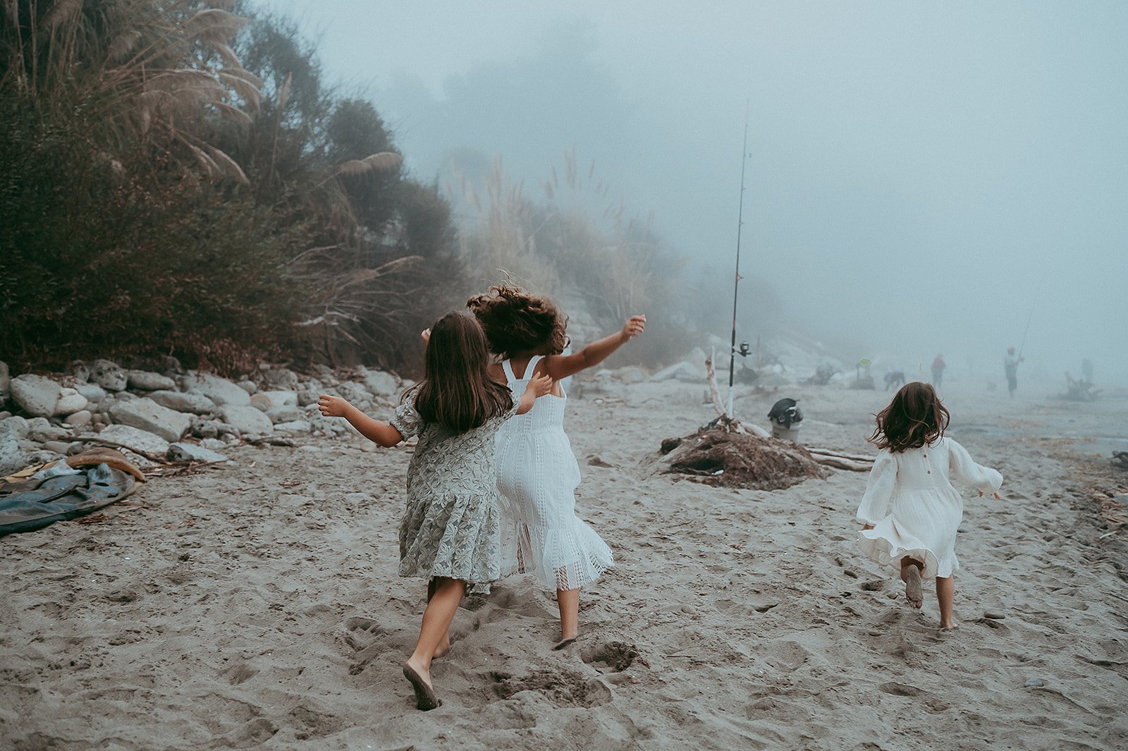 Three sisters running on the beach in Santa Cruz, California. 
