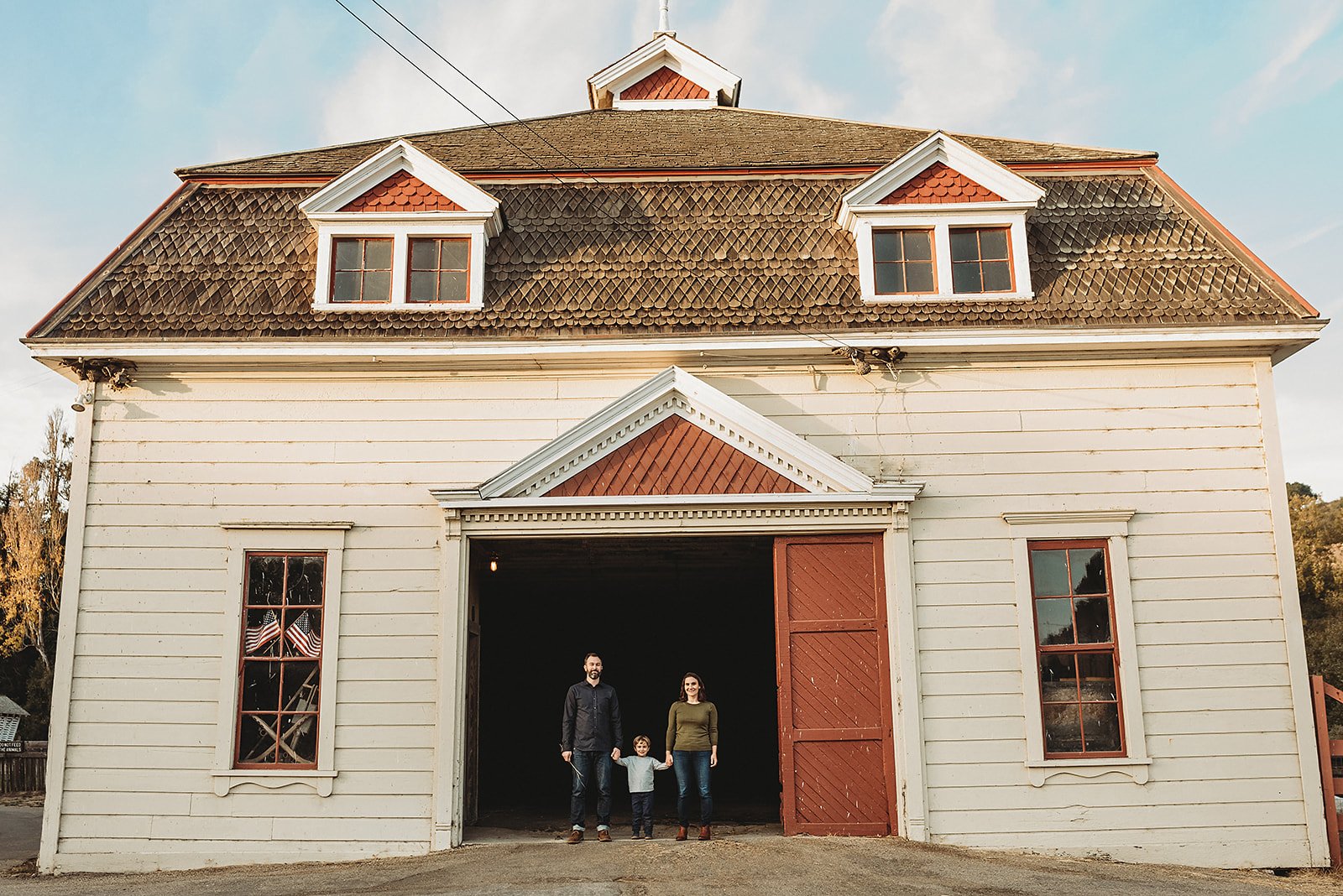 Santa Cruz family photographer session with family standing in a historic barn doorway