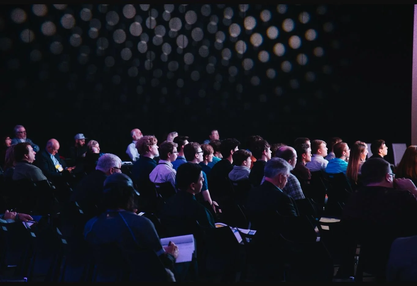 Audience members watching a professional conference presentation