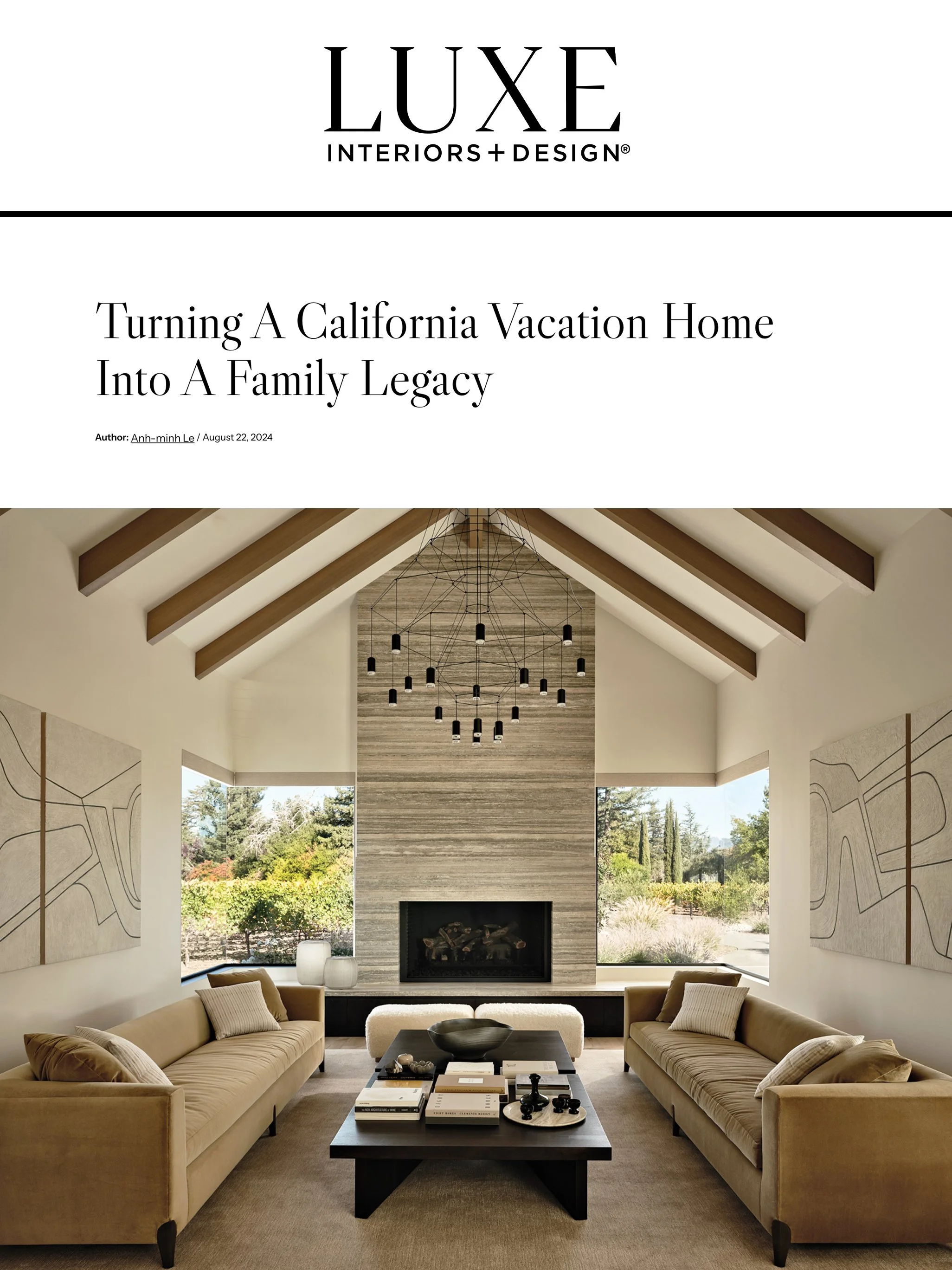 A modern living room with beige sofas, a black coffee table, and a large fireplace with a wood-paneled wall. Large windows showcase a garden outside. The ceiling has exposed wooden beams and a contemporary chandelier.