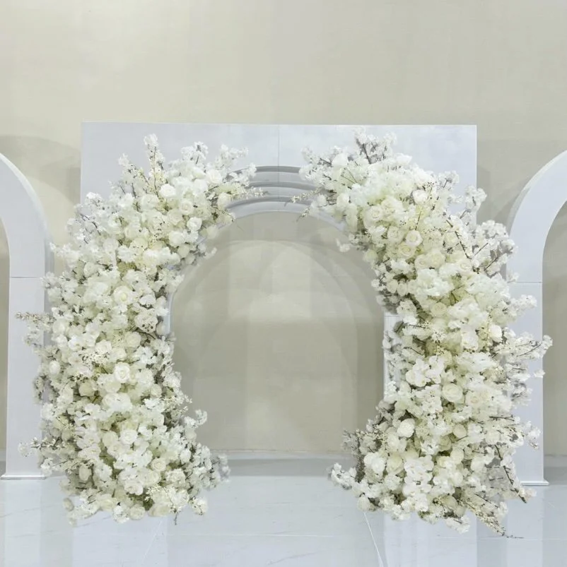 A white floral arch decorated with dense white flowers, likely for a wedding or special event.