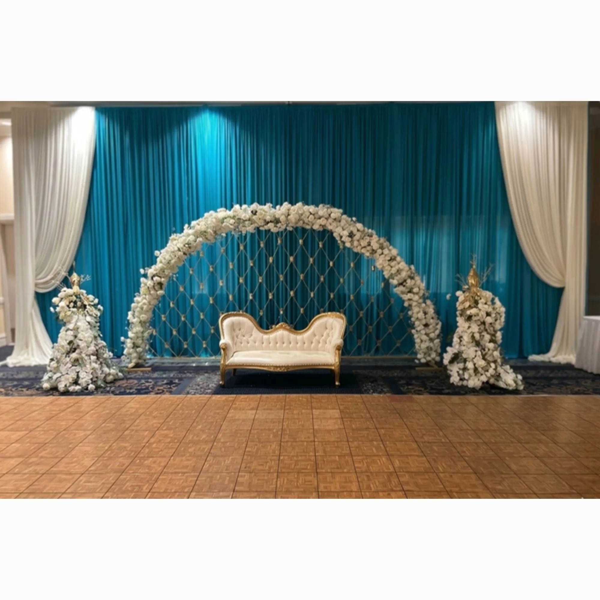 teal-drape-stage-with-floral-arch.jpg