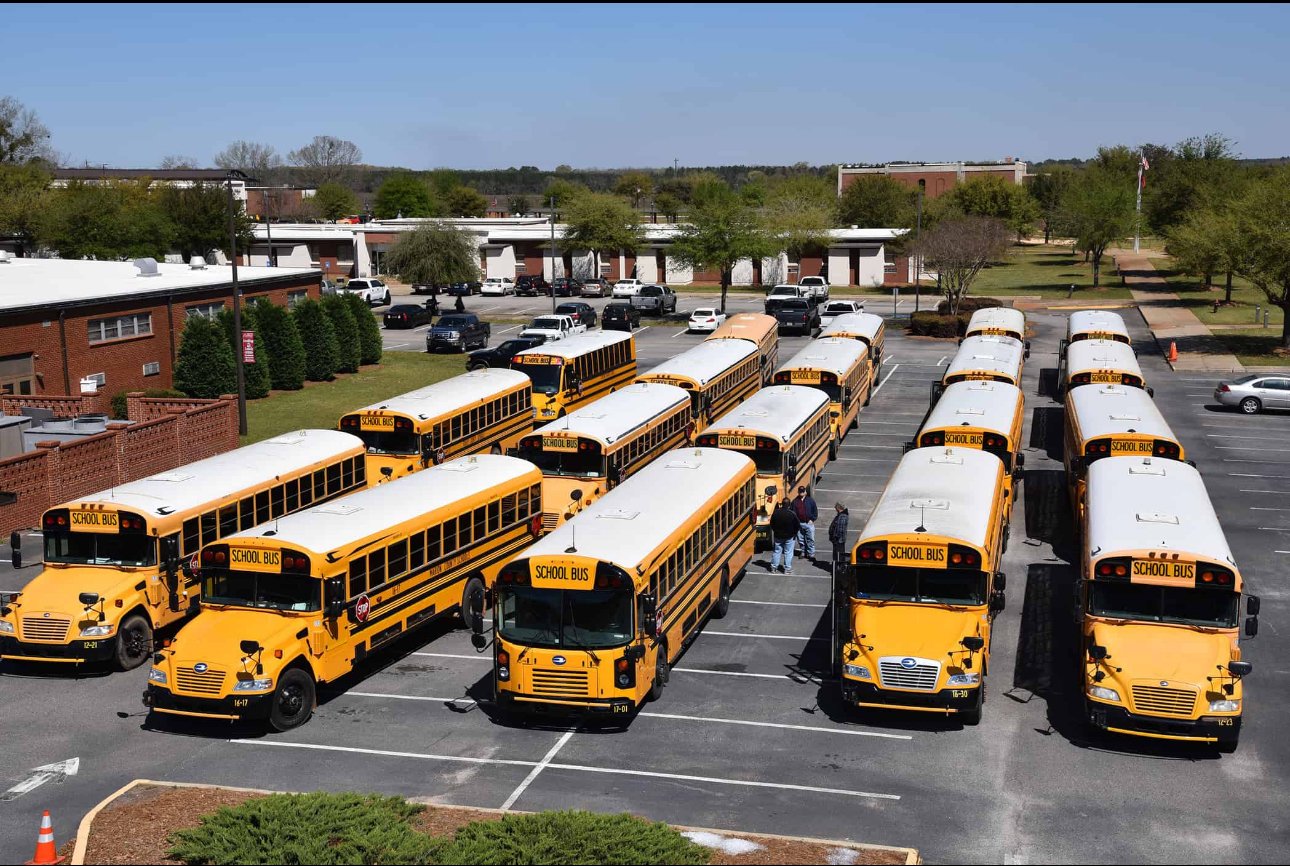 Unit 221 professional school bus driver standing beside a clean, well-maintained school bus
