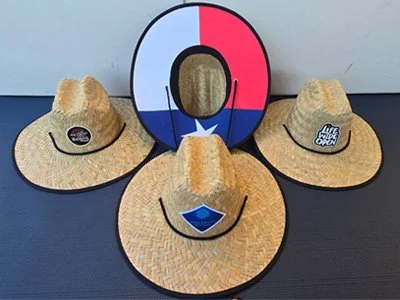 Three straw cowboy hats with patches and a large cutout of the Texas flag in the shape of the letter 'Q'.