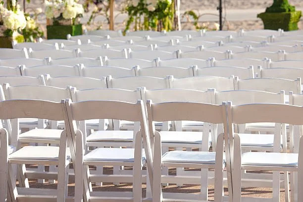 Rows of white chairs set up outdoors potentially for an event or ceremony.