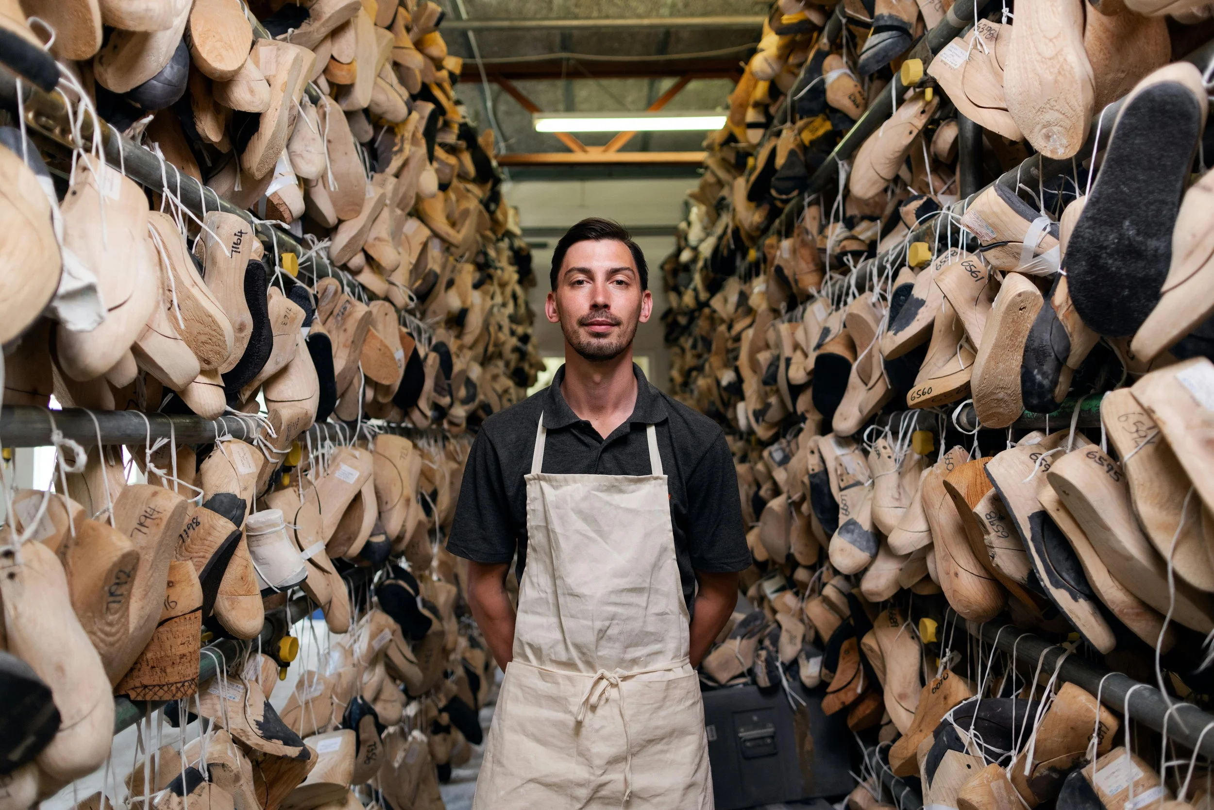 Man standing in the middle of a factory that makes shoes.