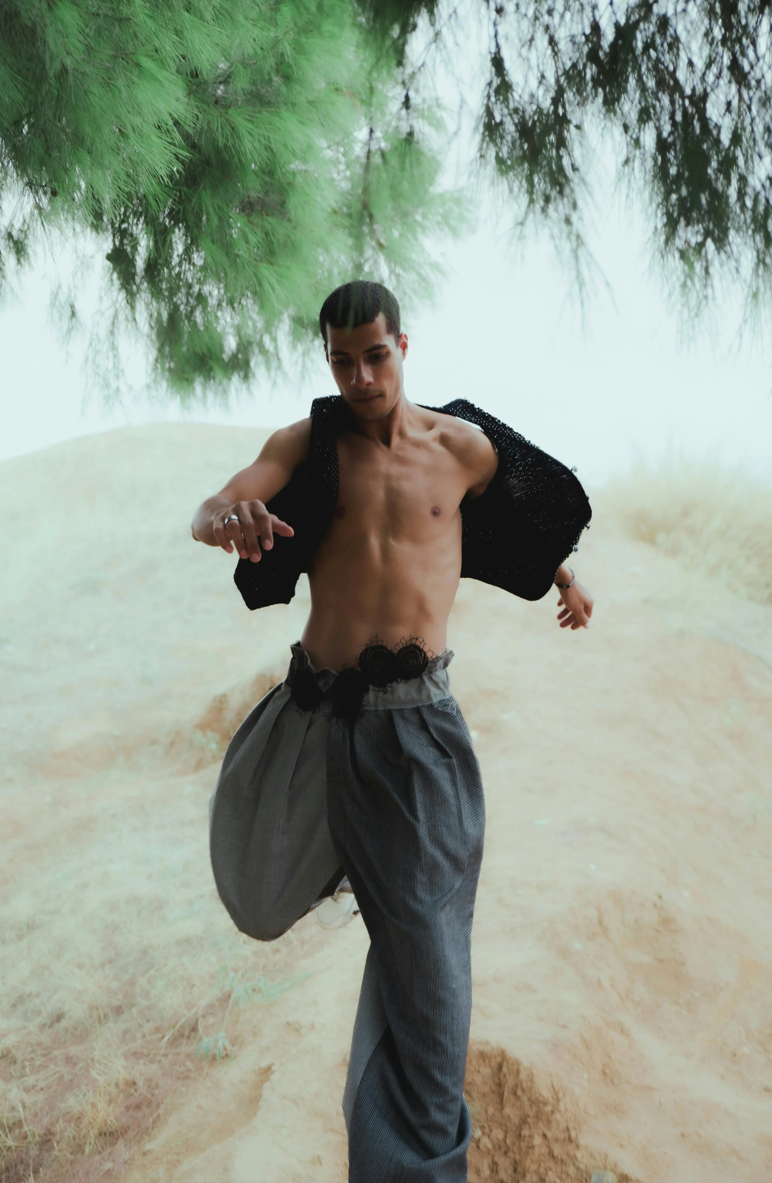 Man running on a nature trail wearing grey pants.
