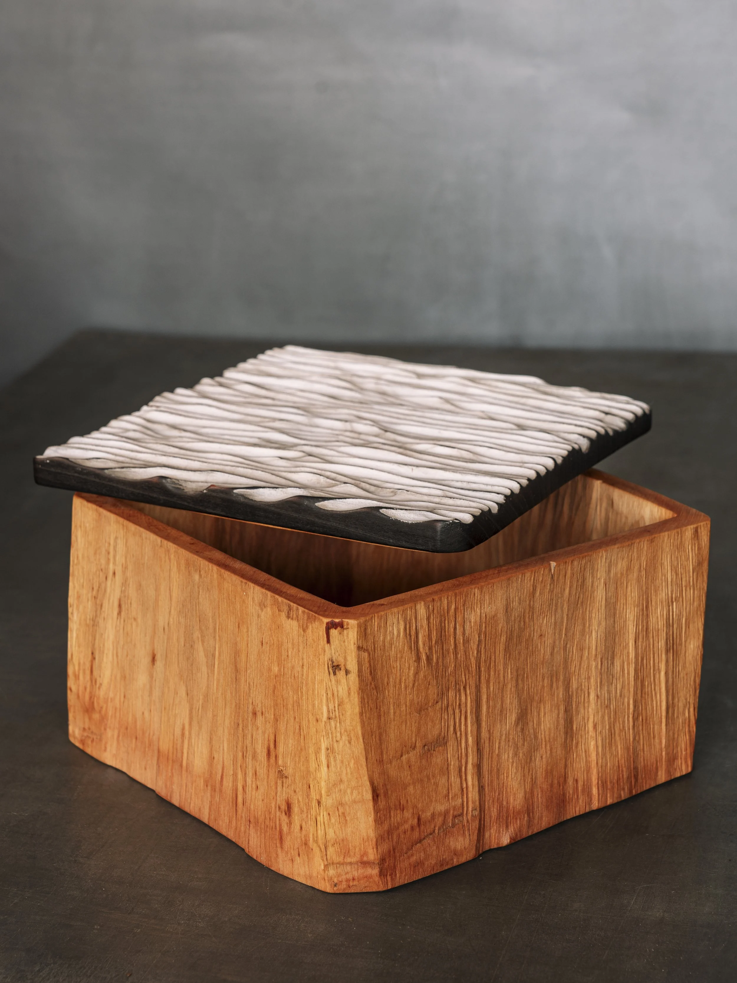 Holzschale mit schwarzem Deckel und weißen, wuerfelartigen Objekten