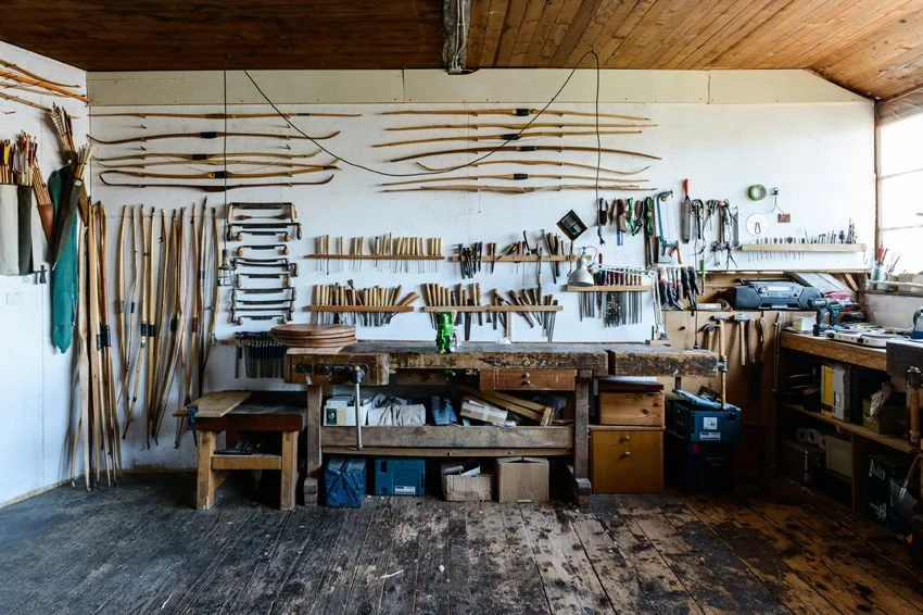 Werkstatt mit Bögen, Werkzeugen und Holzarbeiten