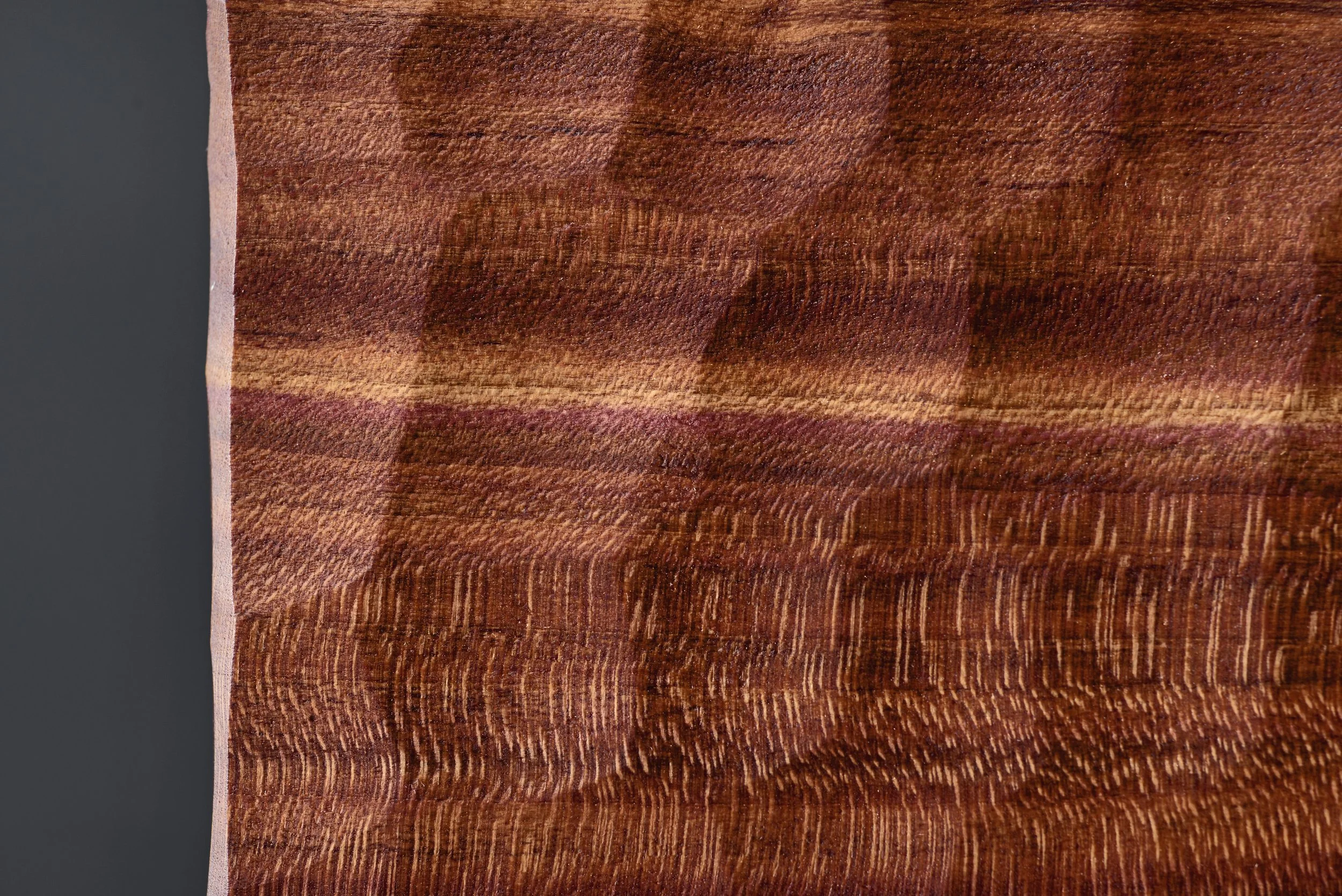 Nahaufnahme eines Holzstücks mit sichtbarer Maserung und naturbelassener Oberfläche.