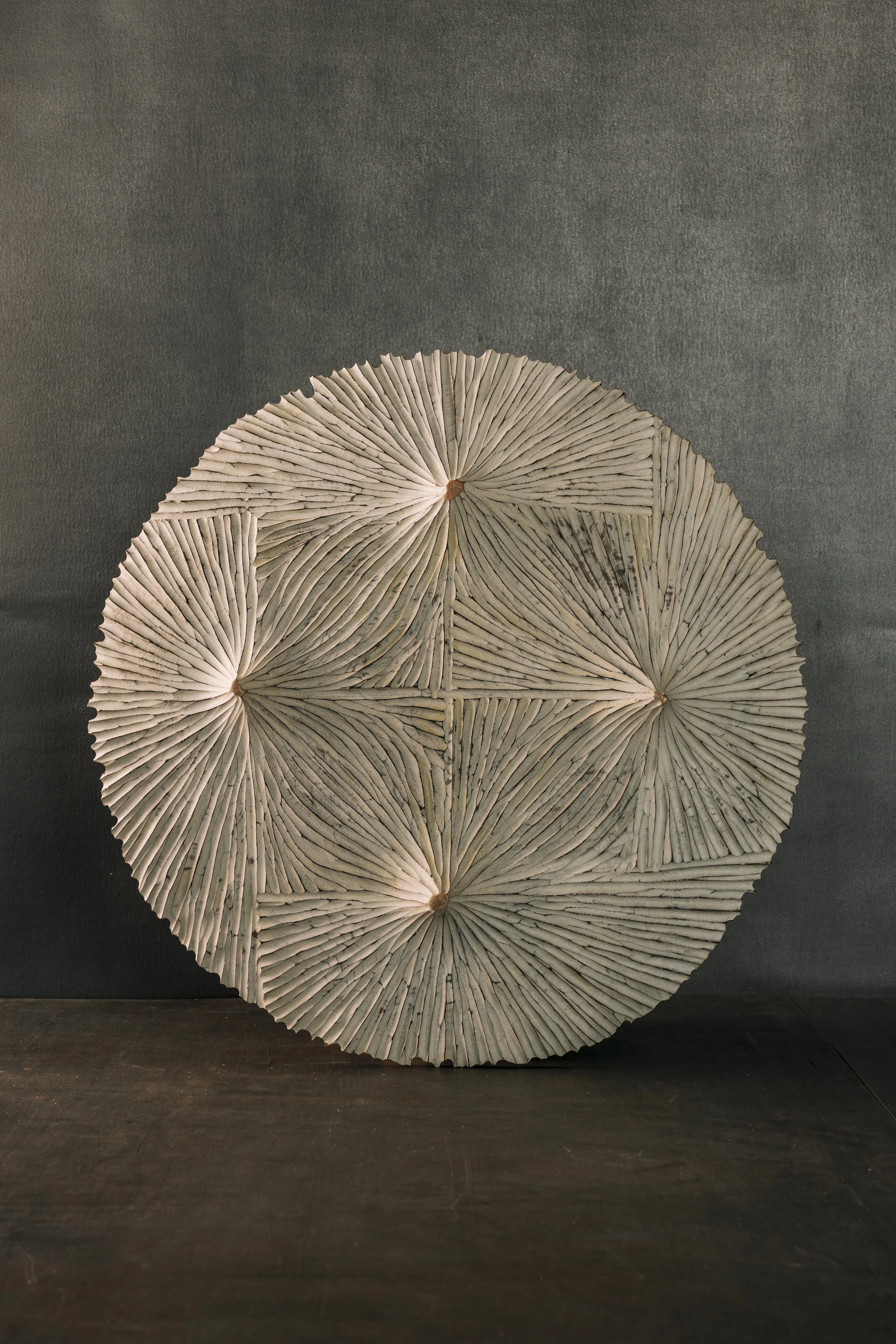 Die Unterseite einer dekorativen flachen Schale, ornamental beschnitzt und weiß gefaßt.