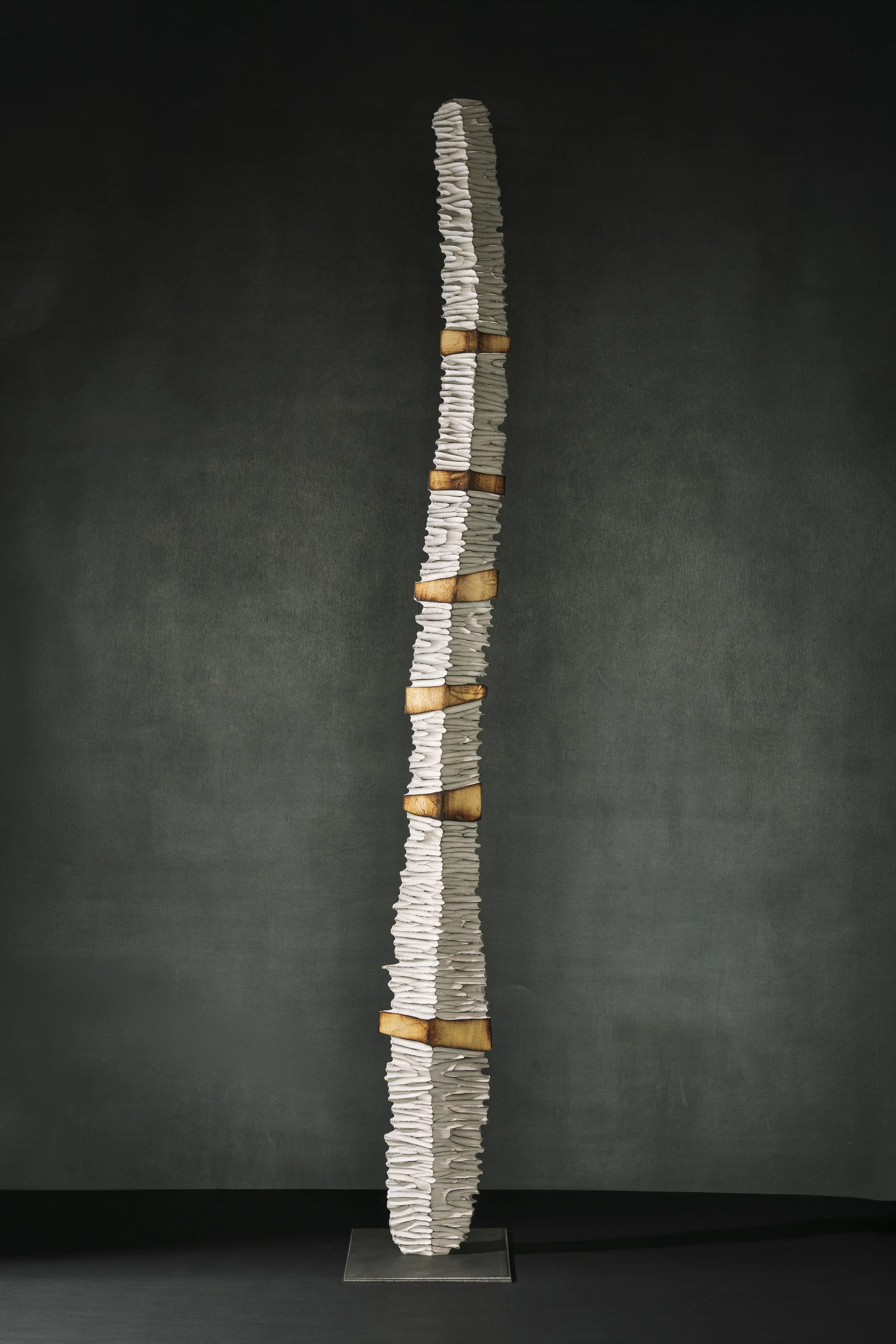 Stelenartige Skulptur mit quergeriffelter Struktur und spannender Licht-Schattenwirkung.