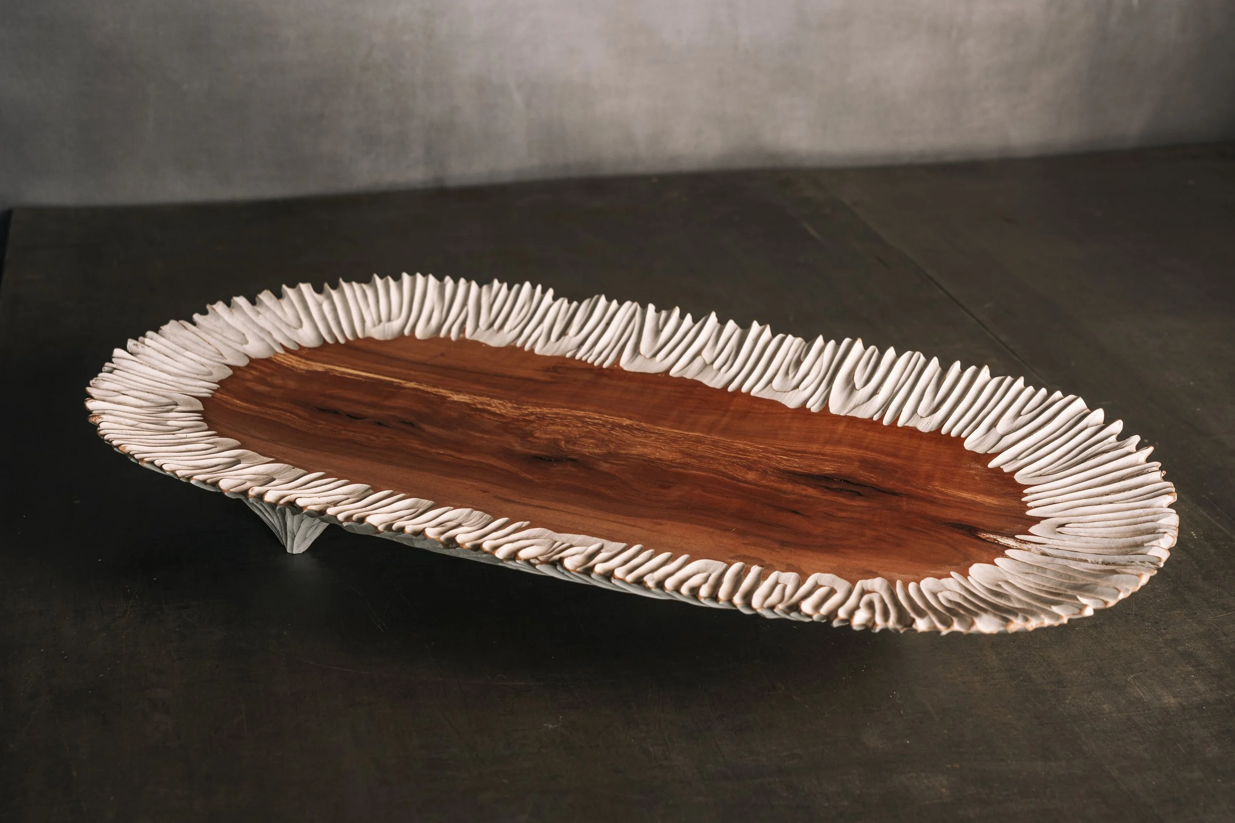 Dekorative flache, längliche Holzschale aus Nußbaum mit strukturiertem geriffelten Rand in weiß.