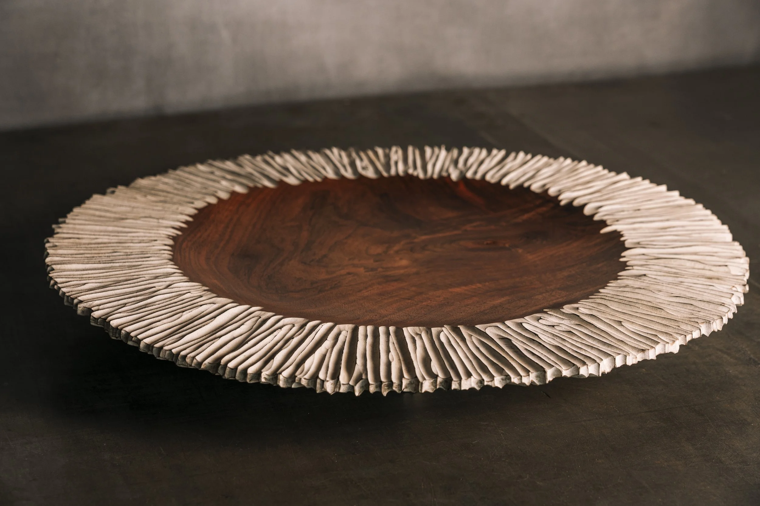Dekorative flache Holzschale aus Nußbaum mit strukturiertem geriffelten Rand in weiß.