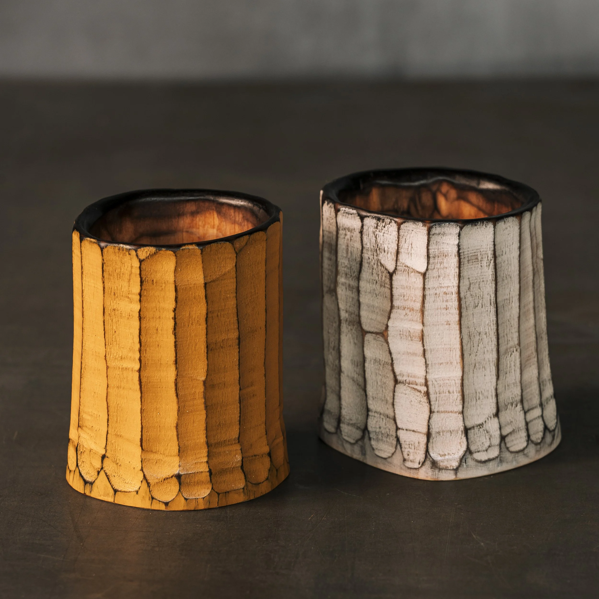 Zwei handgeschnitzte Holzdosen oder Shrinkpots , eine weiß , eine gelb. Die Oberfläche mit vertikalen Hohlkehlen gestaltet.
Fluted Cups.