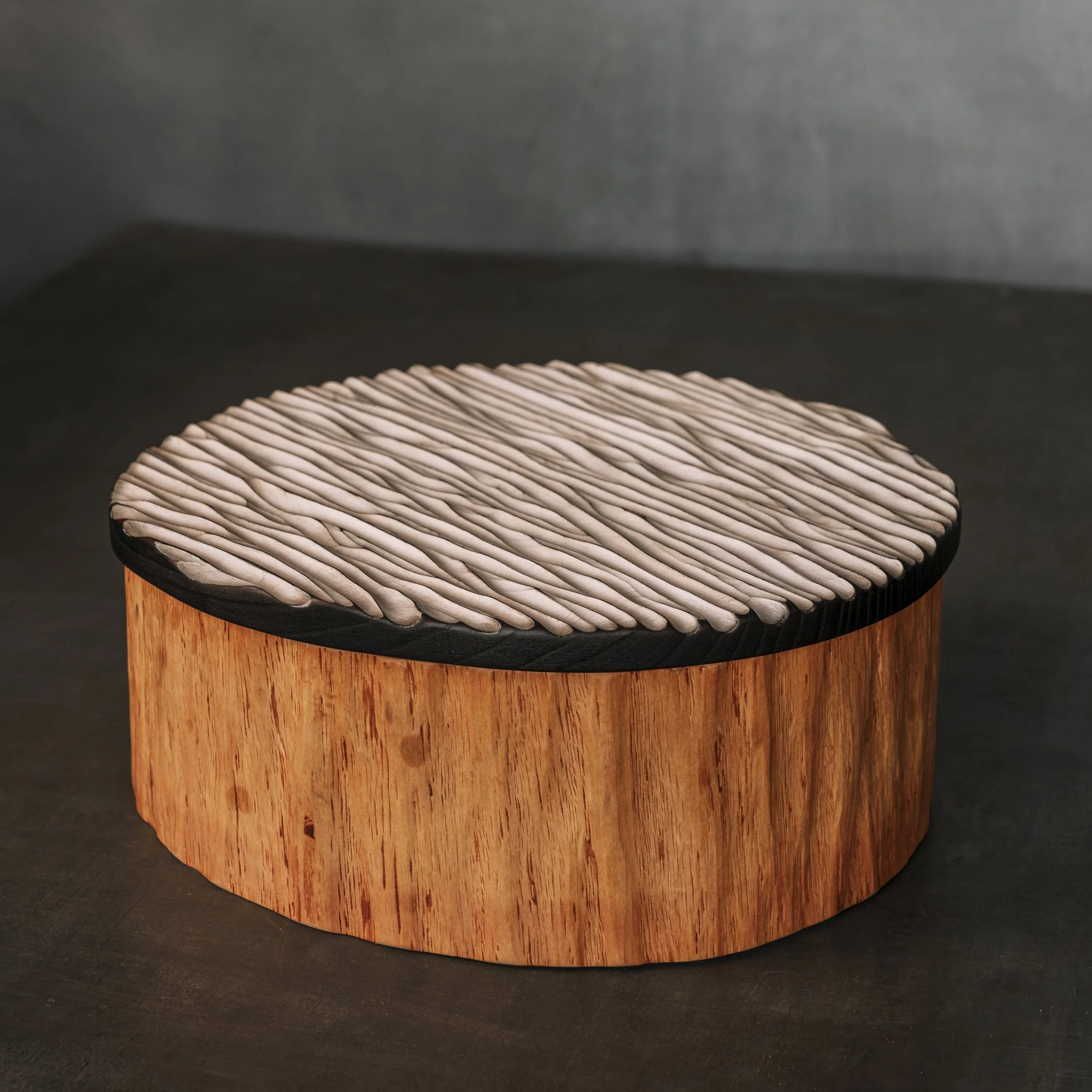 Großer runder Holzbehälter aus einem massiven Stück Holz gearbeitet, auch shrinkpot genannt.
Der Deckel ist mit einer geriffelten Struktur versehen und weiß bemalt.
Holzdose. Urne aus Holz. Milchfarbe.