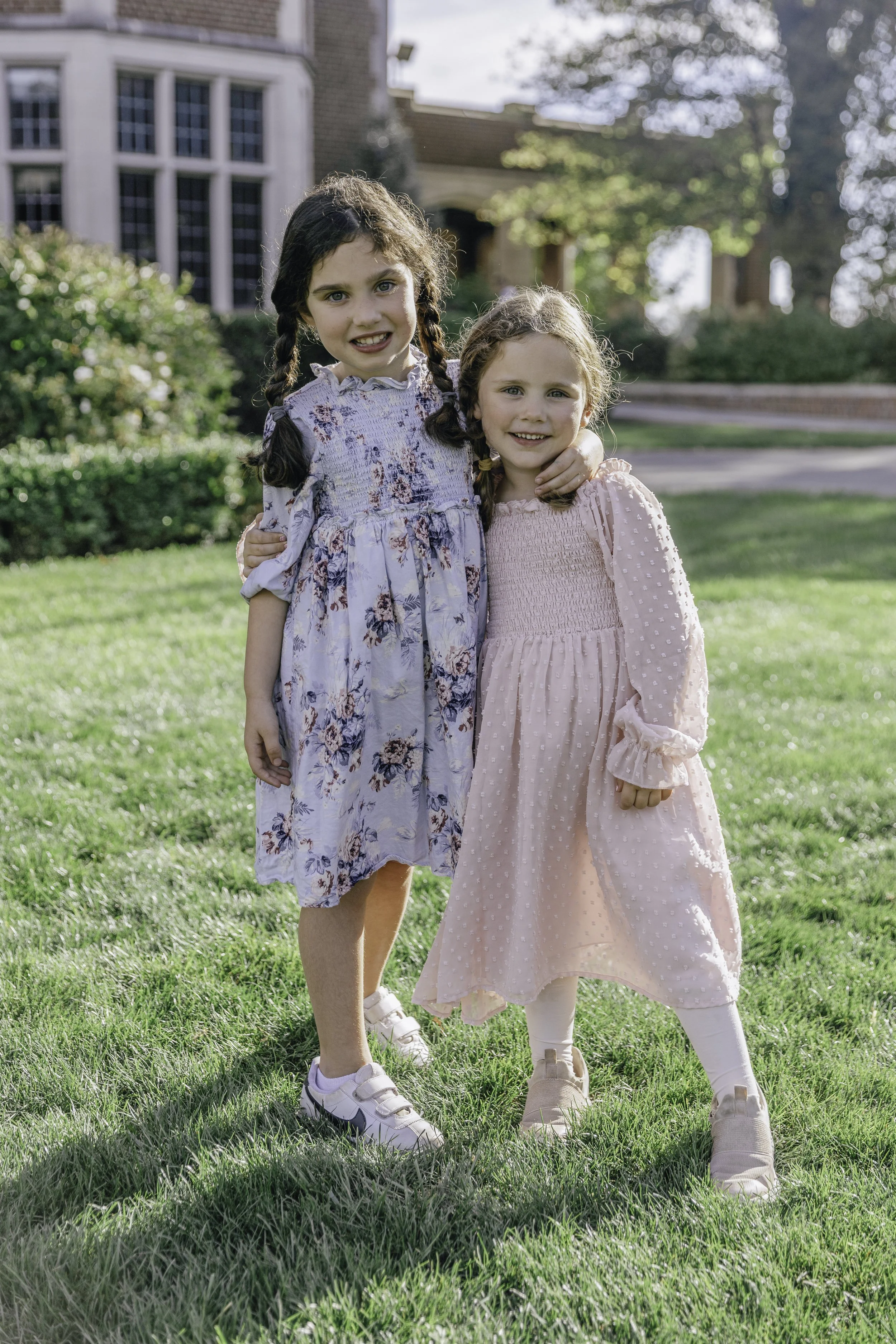 Two young girls smiling and hugging outdoors —New Caanan Connecticut family lifestyle photography