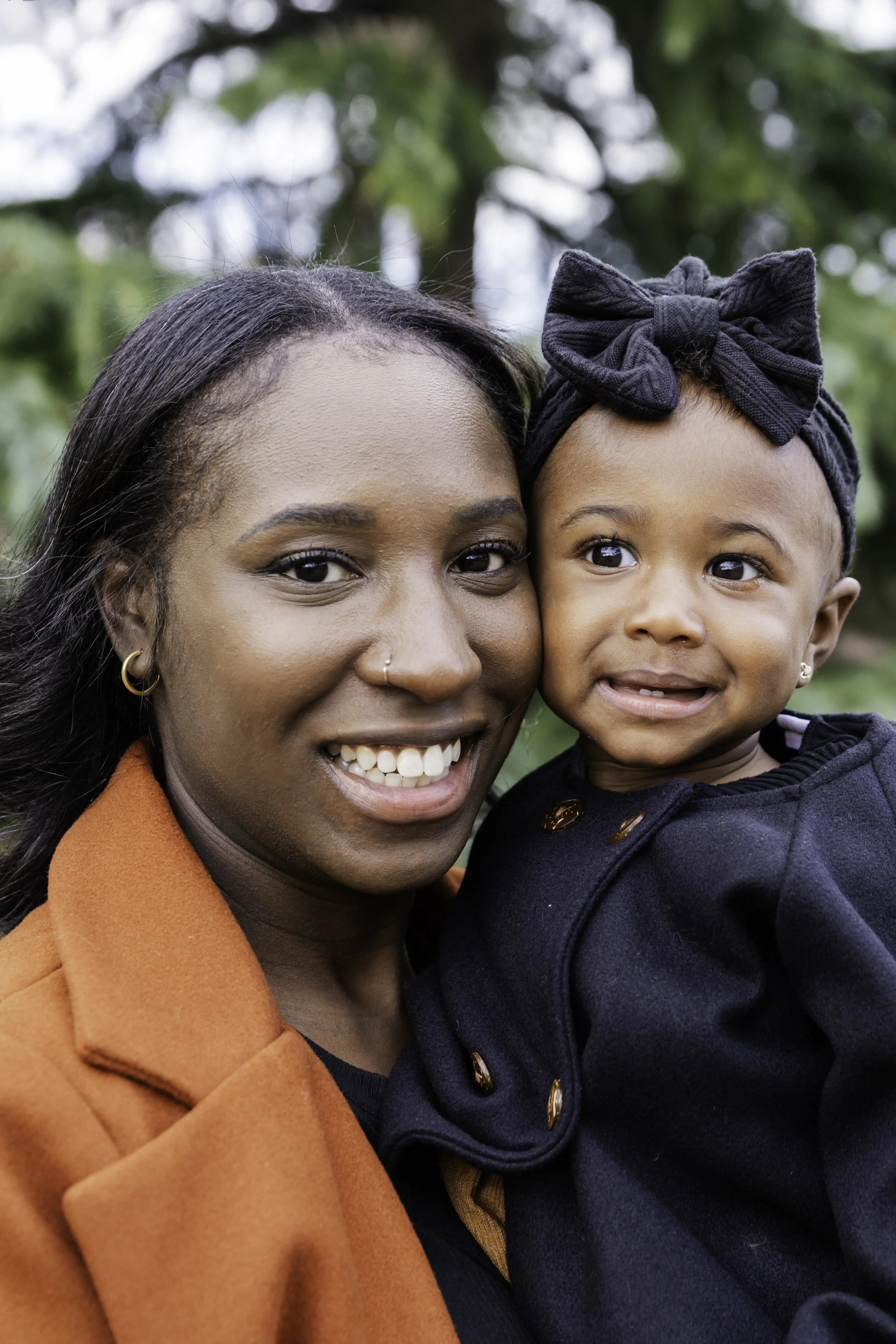 Woman holding young girl outdoors — New York City family portrait