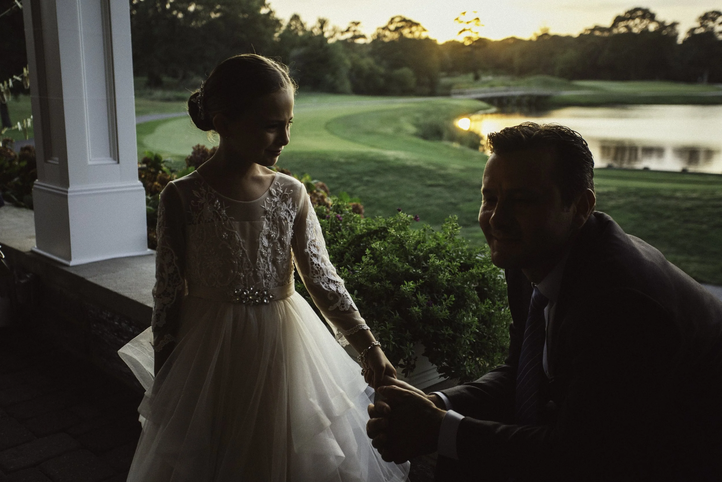 Child and guest holding hands outdoors at NYC wedding
