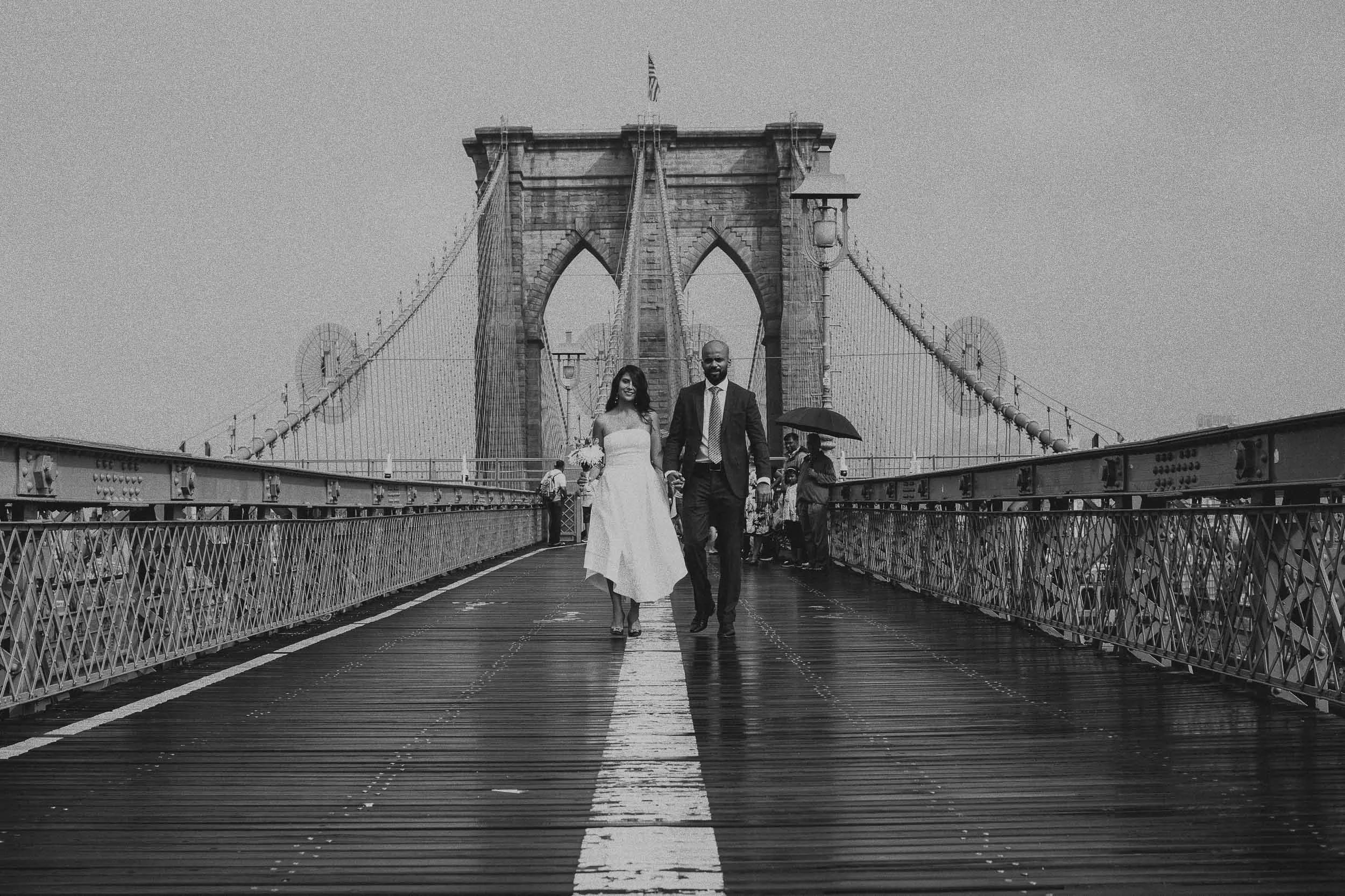 Couple walking hand in hand on Brooklyn Bridge — NYC engagement and wedding photography