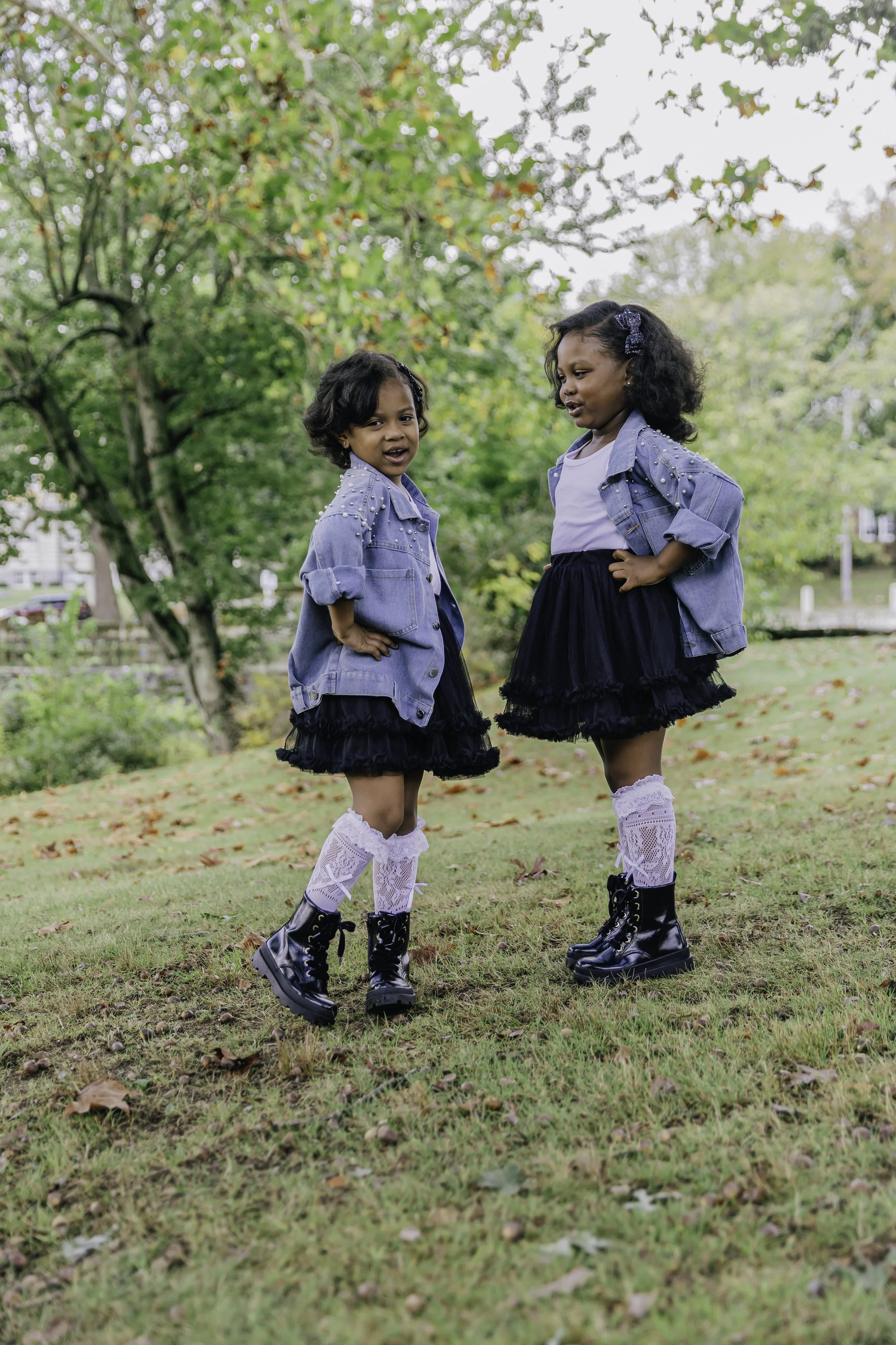 Two girls in denim jackets sitting by park bench — New York City family photography