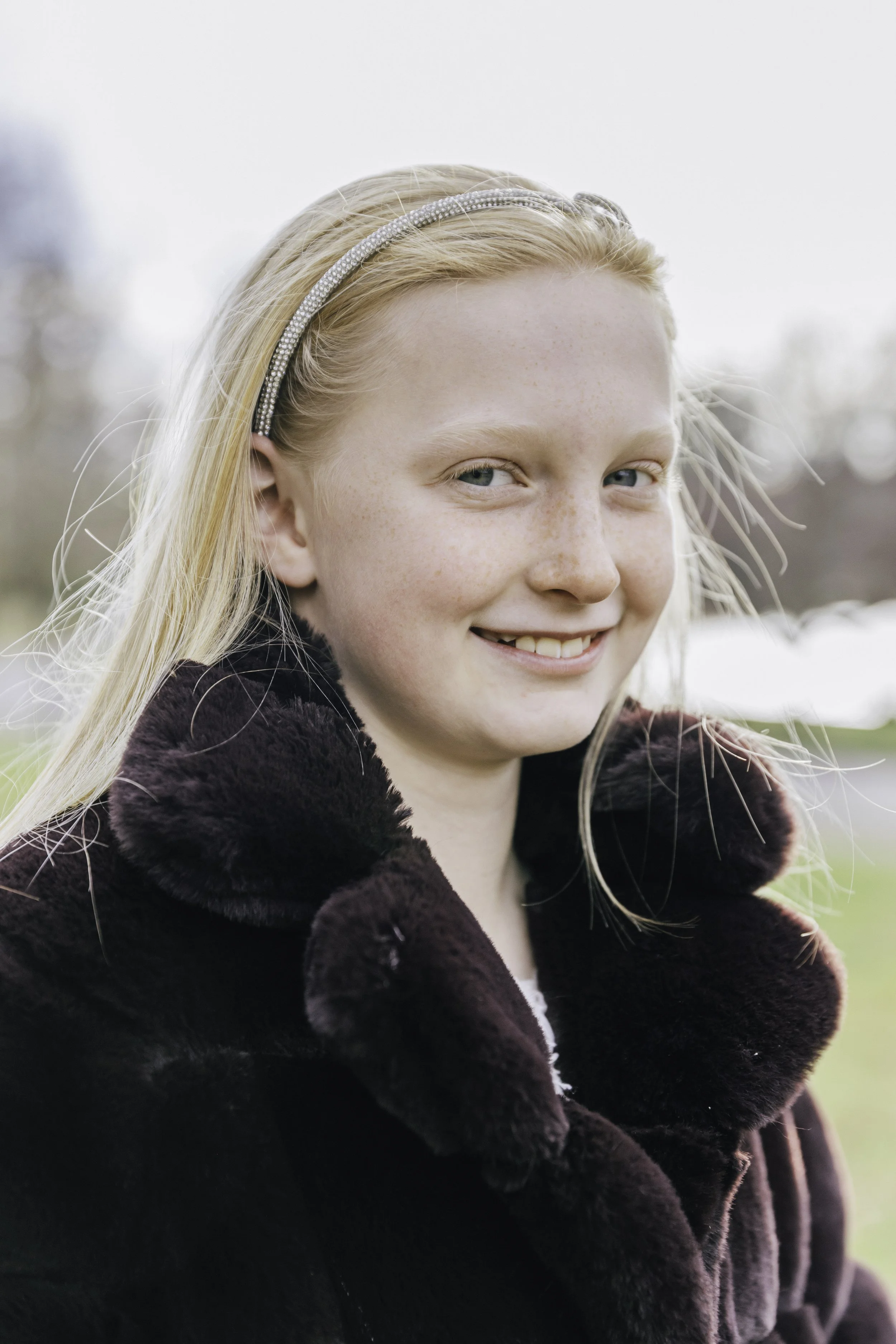 Smiling young girl in Bruce park wearing fur coat — NYC children lifestyle photography