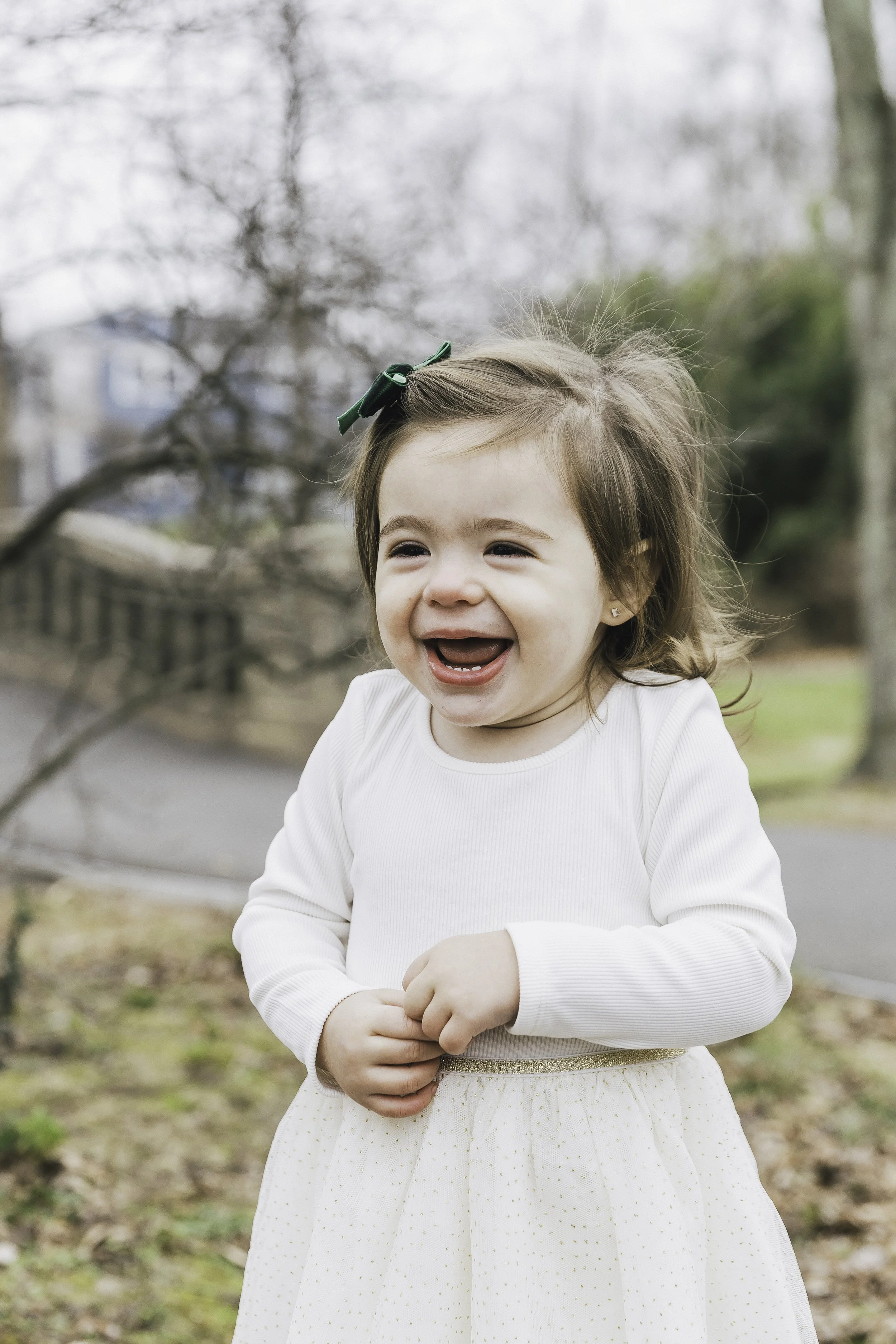 Young girl in white tulle skirt smiling outdoors — NYC family lifestyle session