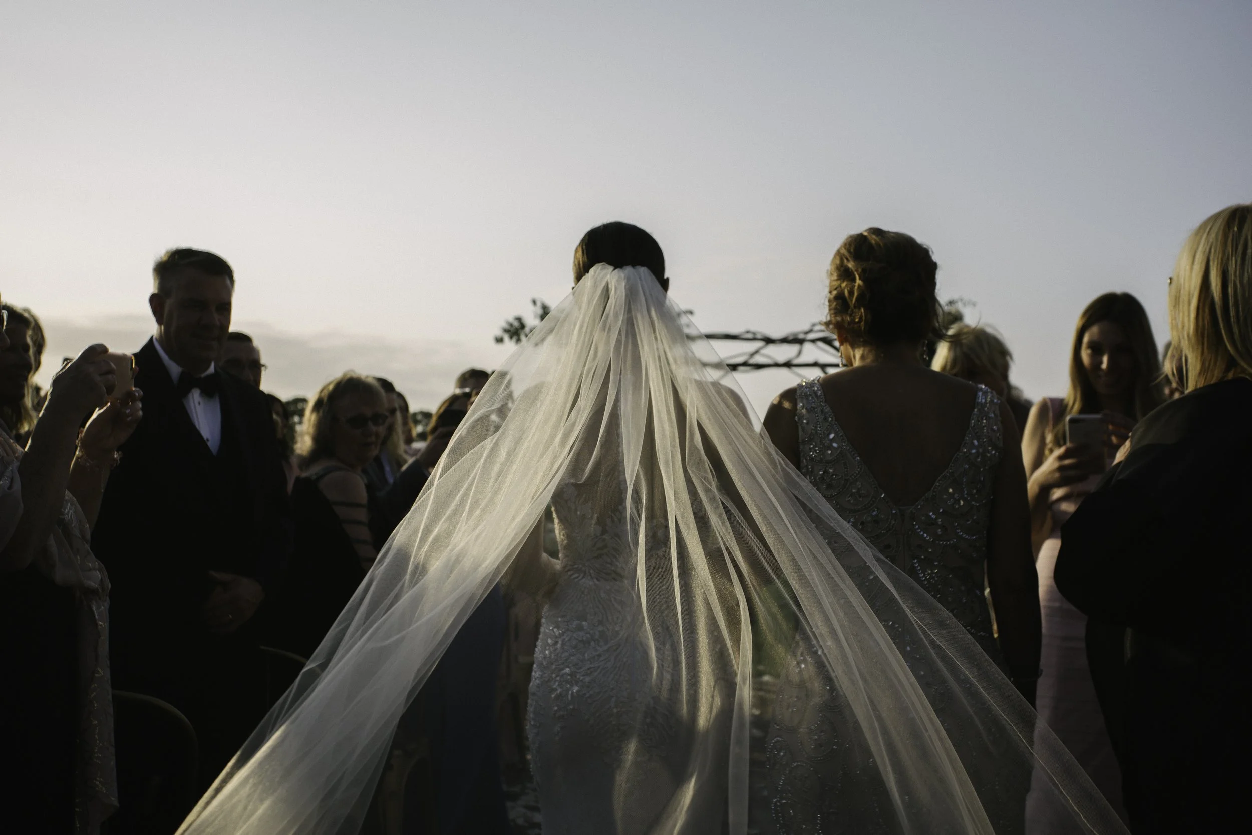 Bride walking outdoors at sunset with guests — NYC wedding photography