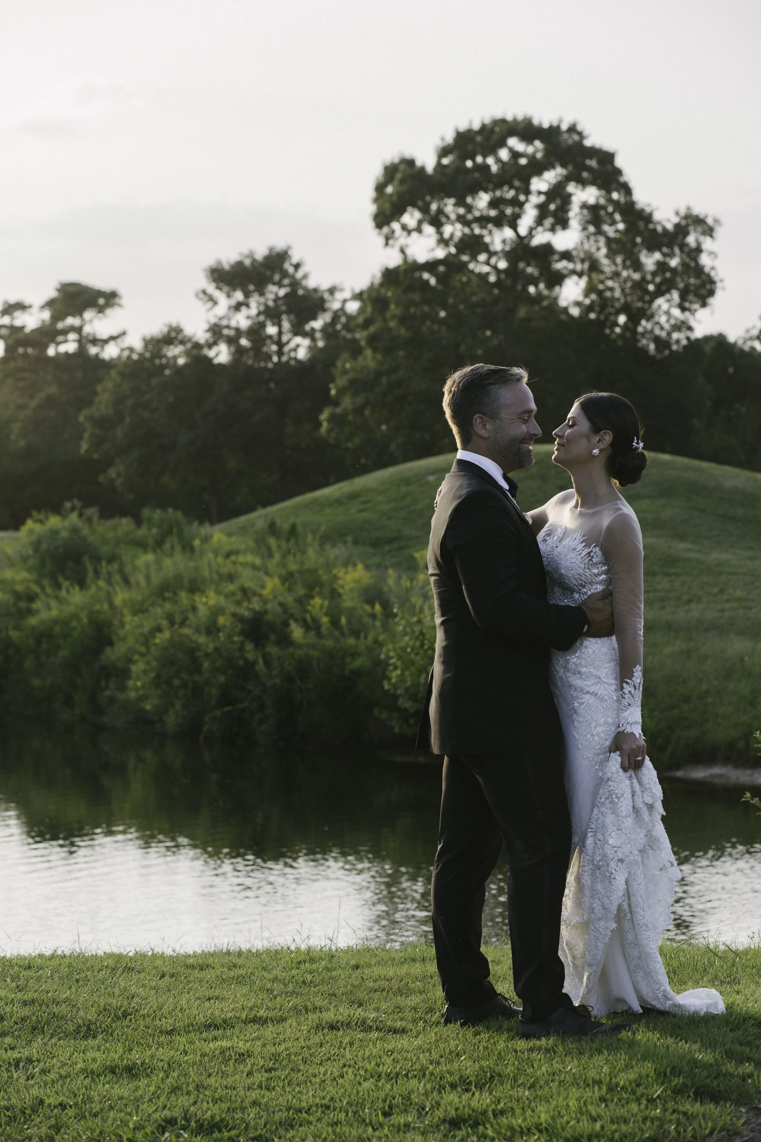 Bride and groom kiss in garden at dusk — New York City wedding photography