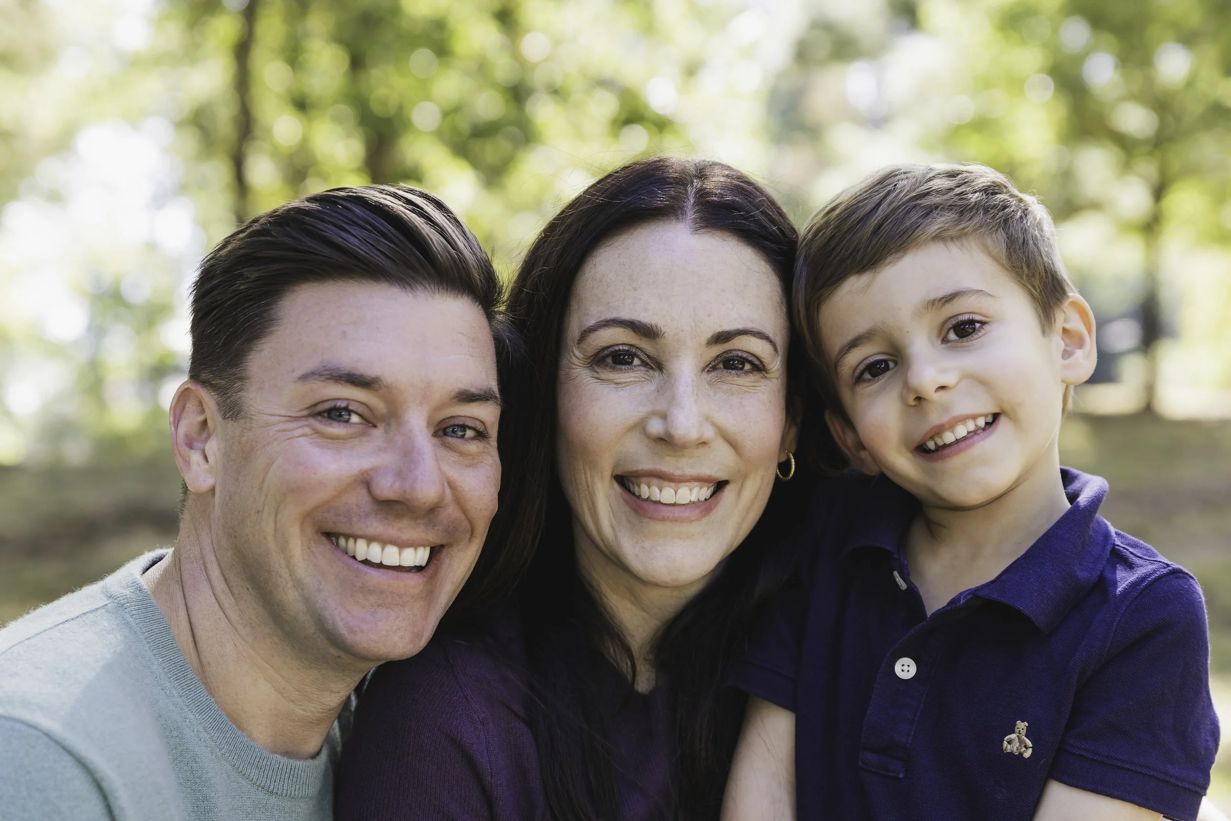 Happy family of three smiling outdoors — NYC family lifestyle photography