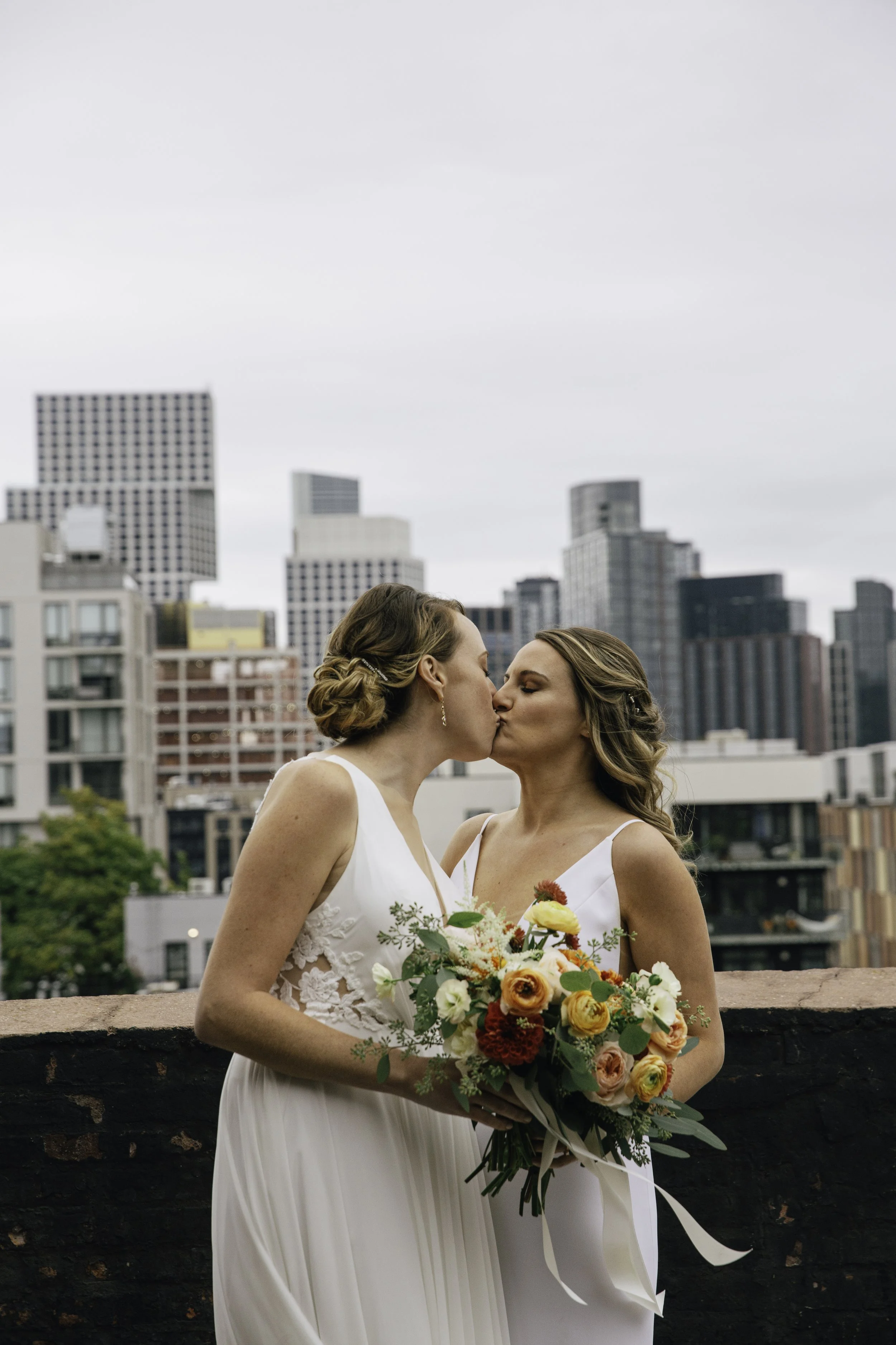 Couple embrace outdoors with city skyline backdrop — NYC wedding photography