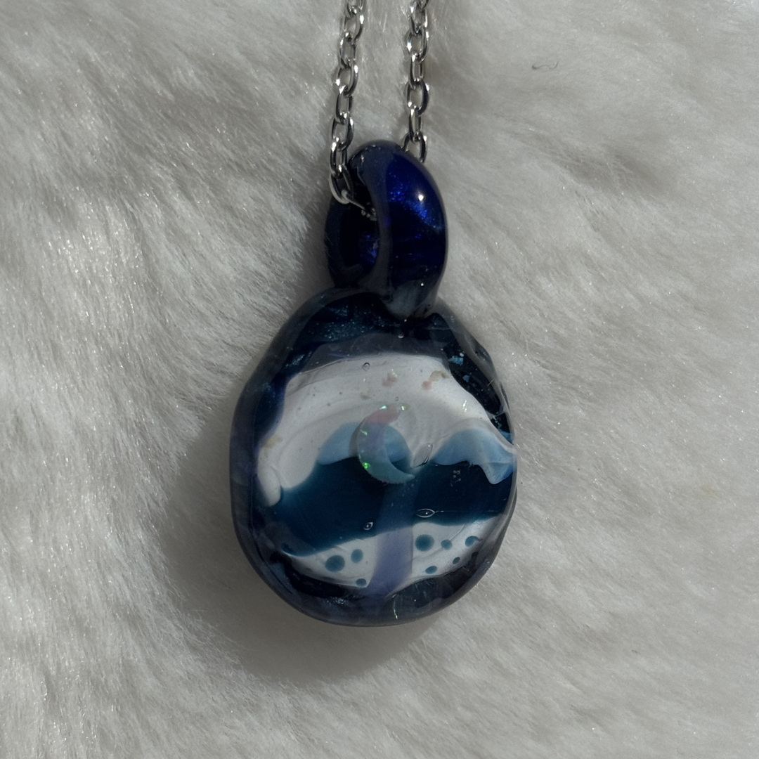 Close-up of crushed opal moon and sapphire mountains borosilicate glass pendant by Sumuji Glass