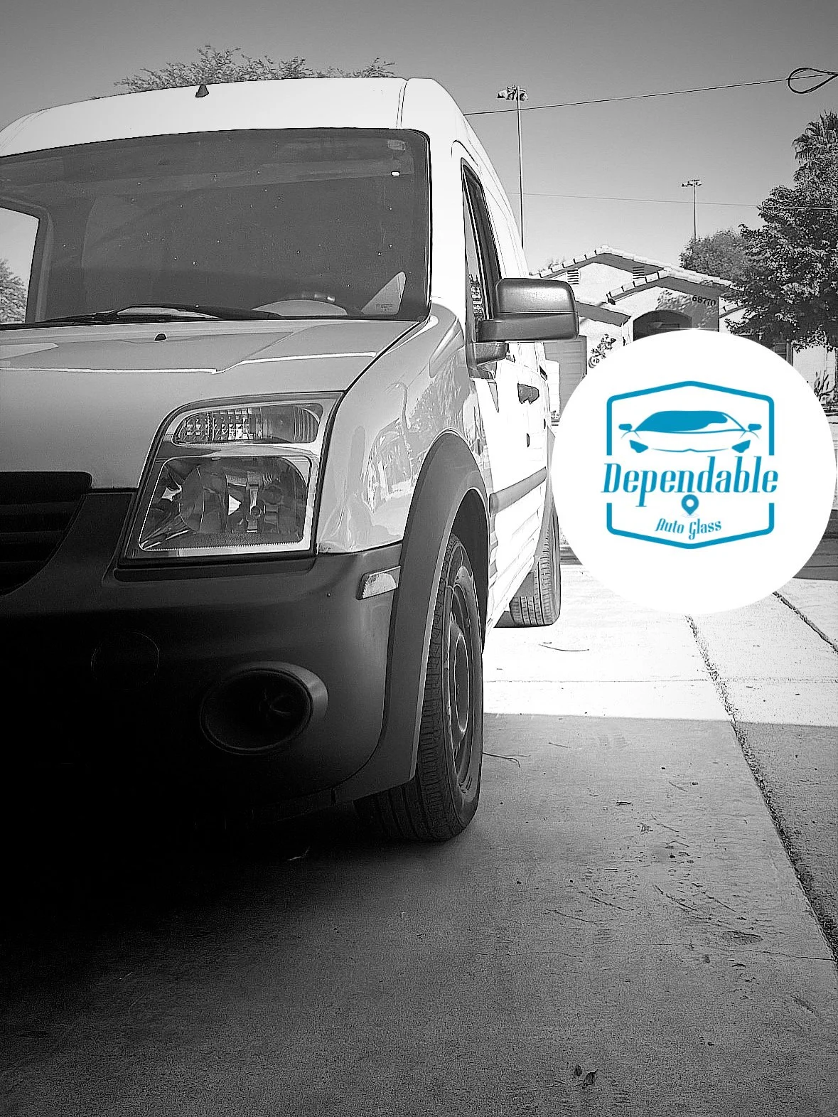 A white van parked on a concrete driveway with a logo that reads 'Dependable Auto Glass' featuring a stylized car.