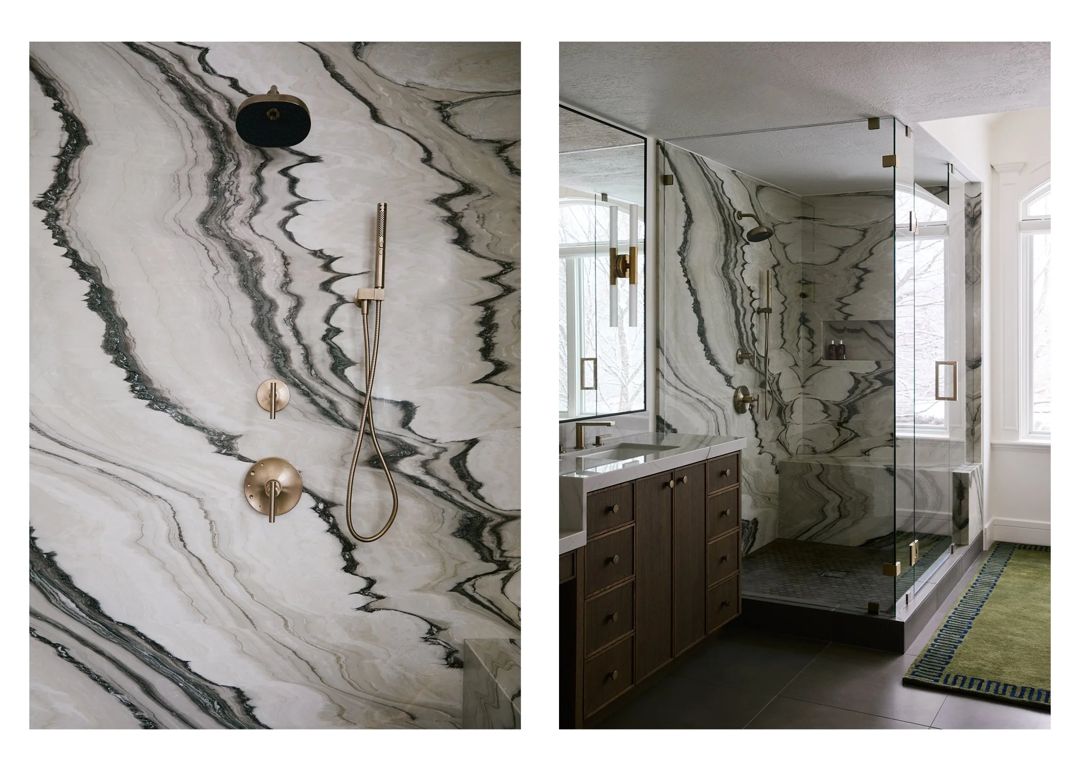 A modern bathroom with a marble shower featuring black and white swirling patterns, brass fixtures, a large window, a wooden vanity with a white countertop, a glass partition, a green rug with a geometric border, and a view of trees outside.