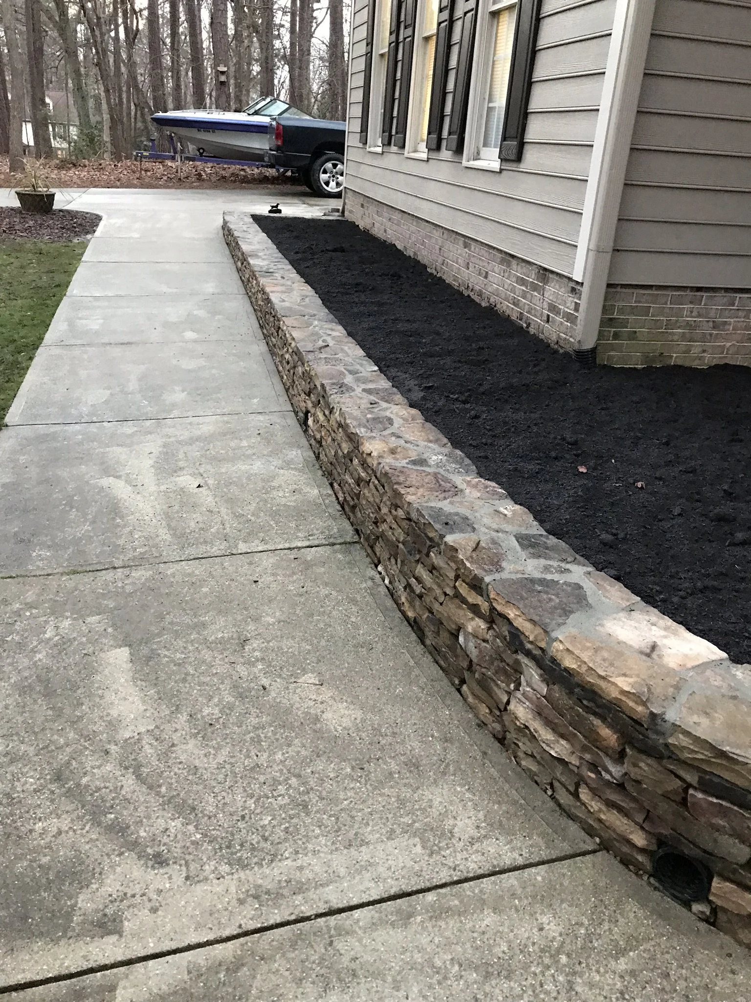 custom natural stone planter retaining wall along front walkway