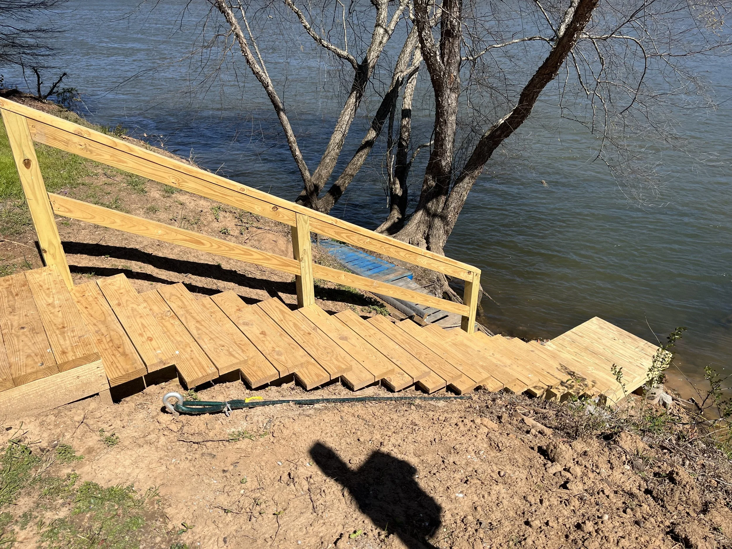 custom wood stairs and railing leading to lake